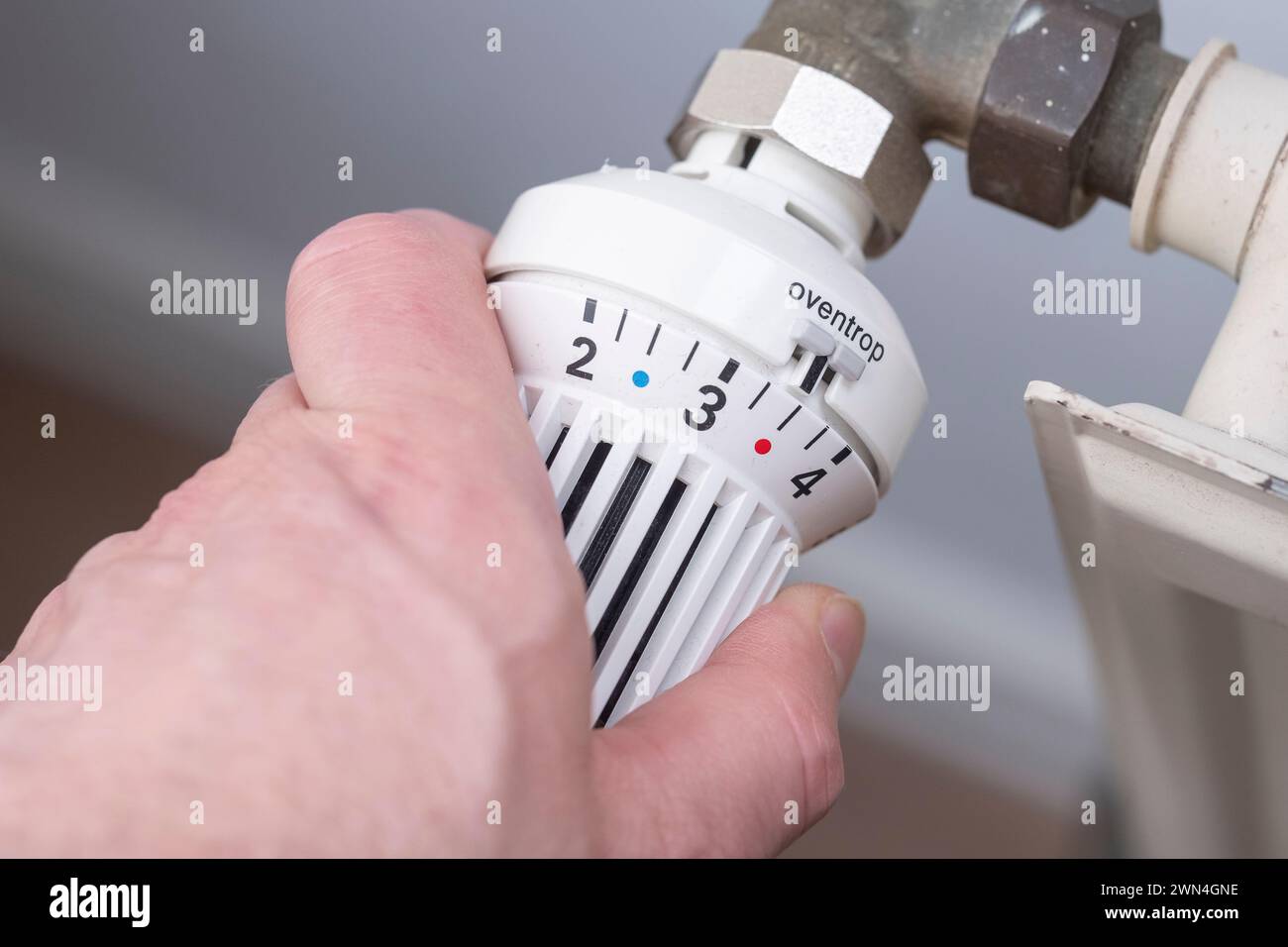 Mano su una valvola del radiatore Foto Stock