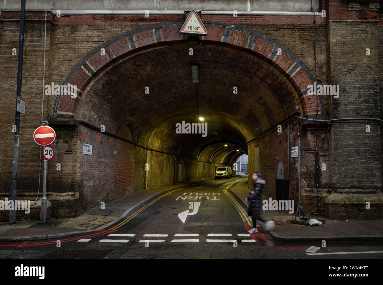 Bermondsey, Londra, Regno Unito: Shand Street che passa attraverso un tunnel stradale sotto il London Bridge fino al Greenwich Railway Viaduct. Incrocio con Crucifix Lane. Foto Stock