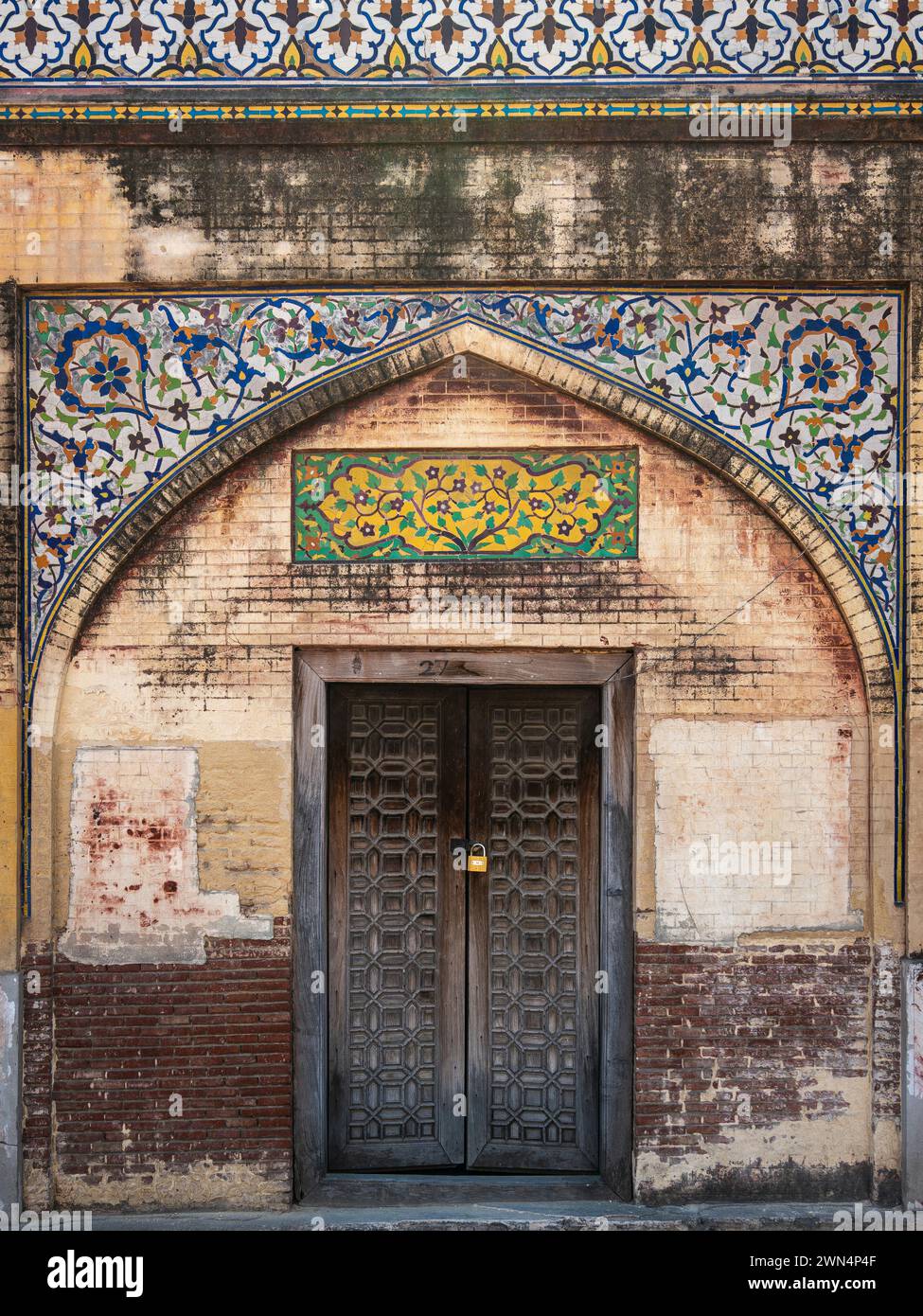 Una porta di legno presso il monumento storico Masjid Wazir Khan, una moschea moghul del XVII secolo situata nella città di Lahore, Punjab, Pakistan. Foto Stock