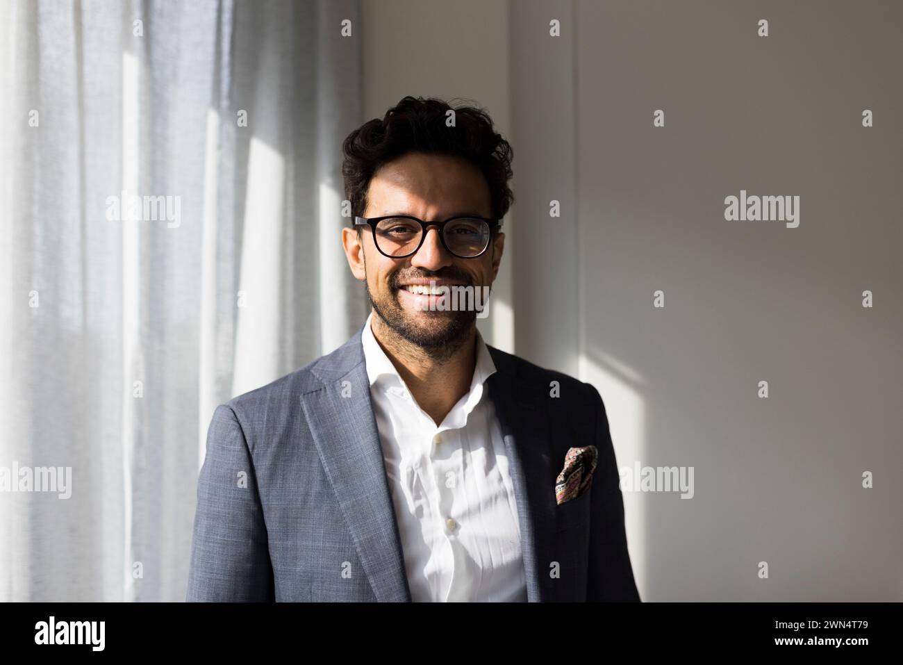Ritratto di un agente immobiliare maschio sorridente nella nuova casa Foto Stock