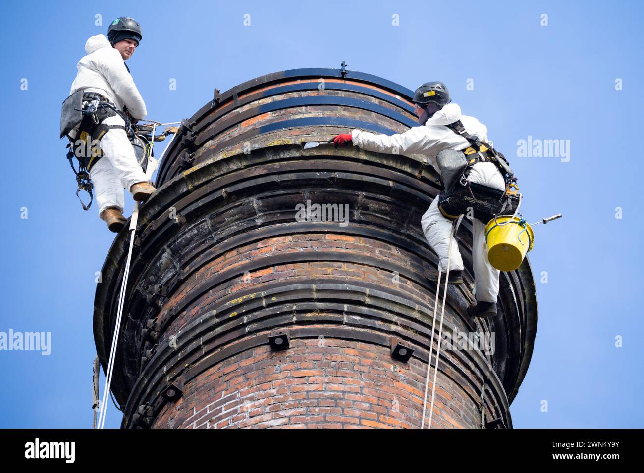 01/04/22 Steeplejack scala il camino Milford Mill alto 43 metri per mantenere e rendere la struttura sicura. Struttura classificata di grado II costruita nel 18 Foto Stock