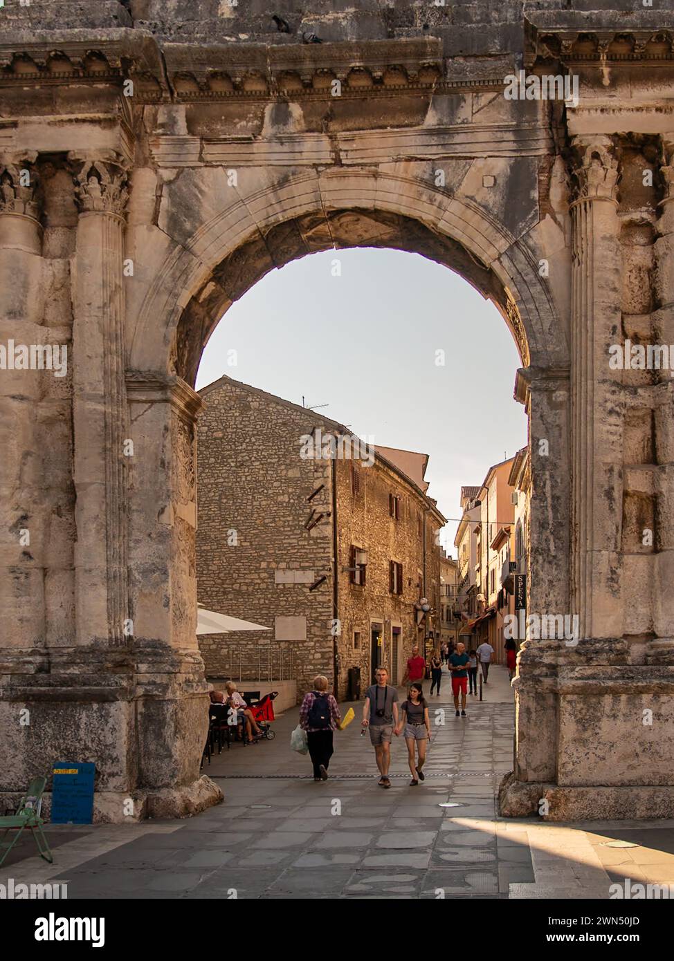 Turisti sotto l'Arco Sergio - arco trionfale romano della famiglia Sergio costruito nel 29 a.C. Pola, Pola, Istria, Croazia Foto Stock