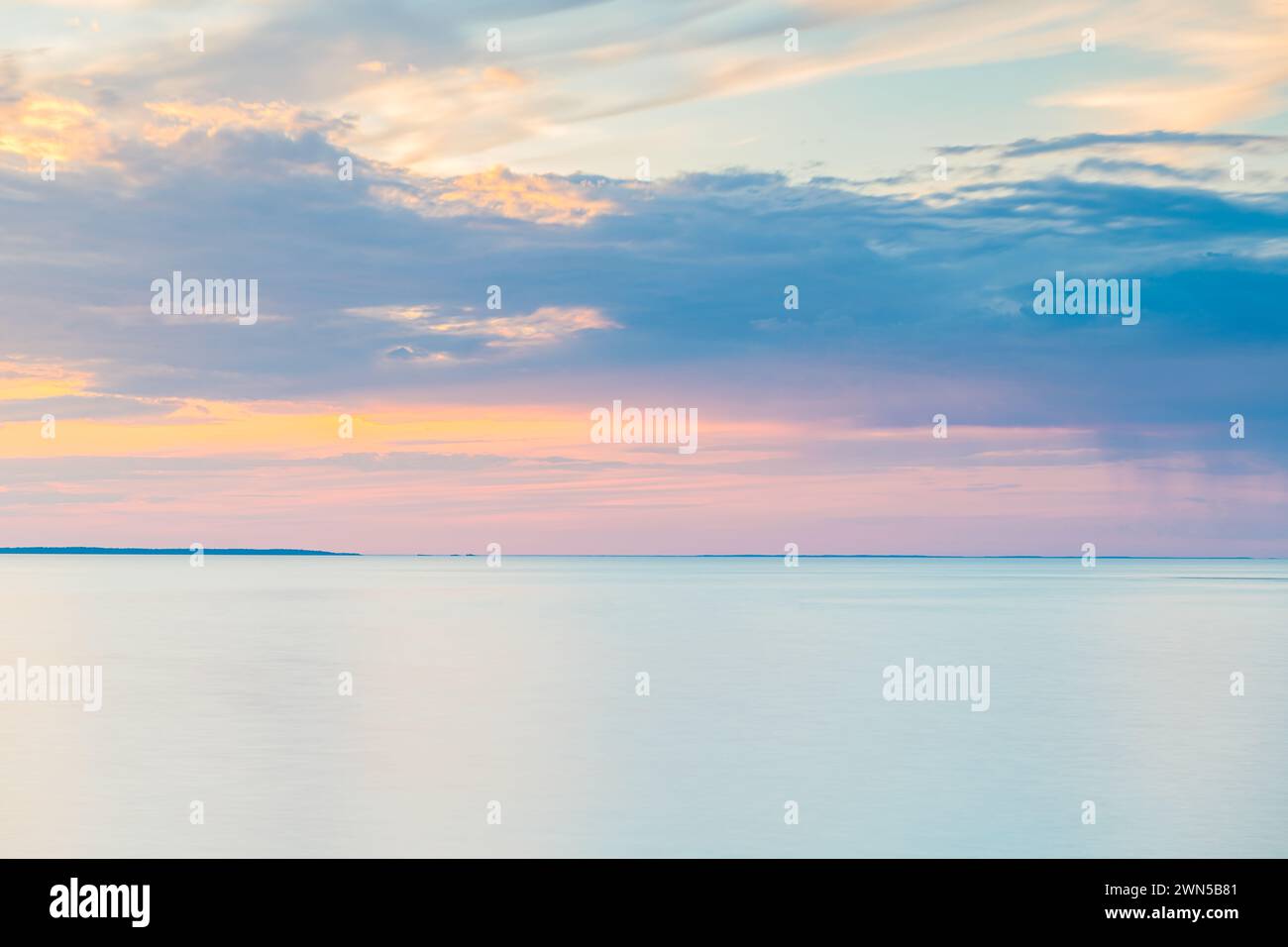 Una vasta distesa d'acqua, probabilmente un lago, si estende sotto un cielo pieno di spesse nuvole scure. La scena suggerisce un'imminente tempesta o un rovesciamento Foto Stock