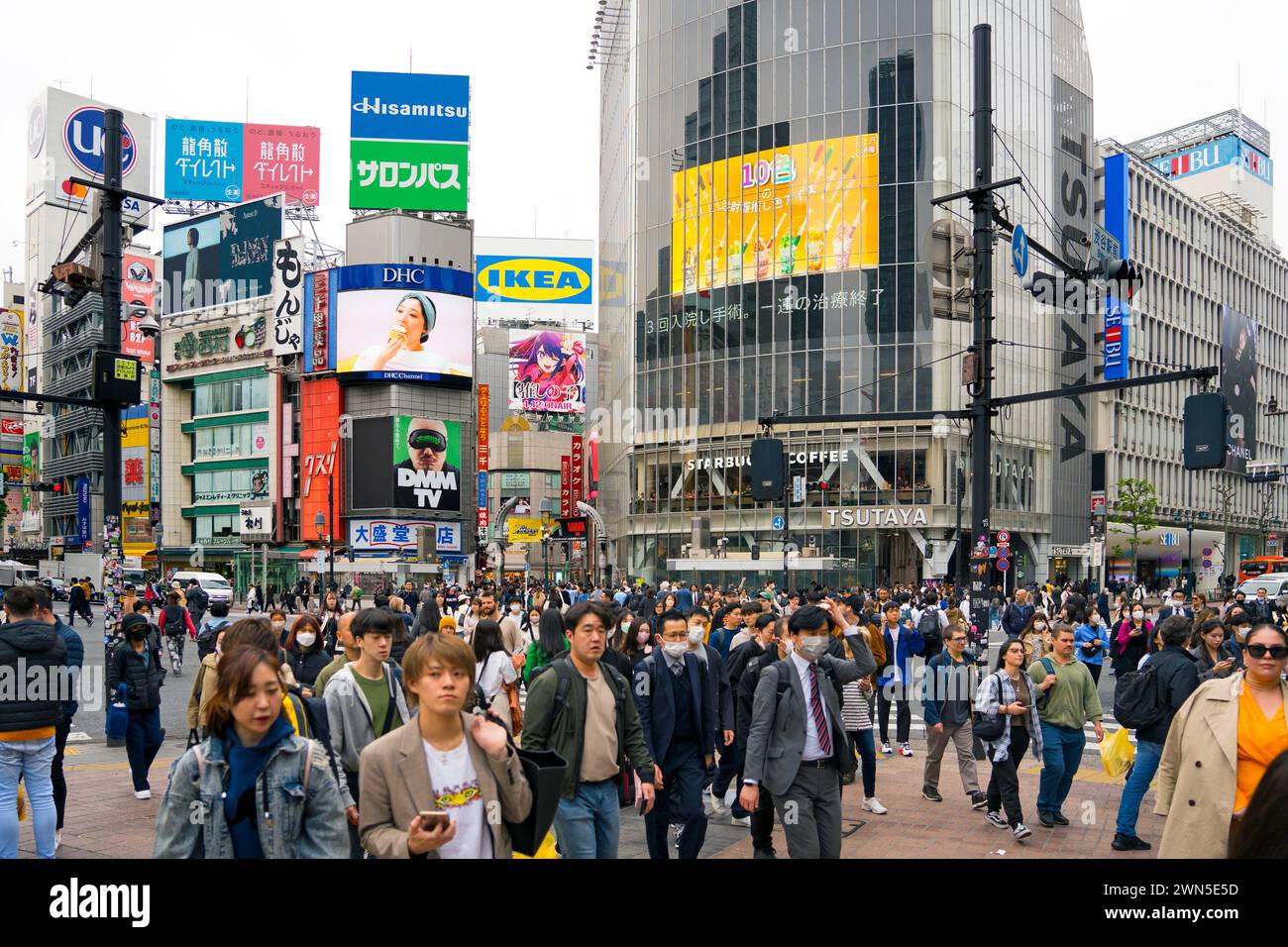 Cartelloni pubblicitari digitali e pedoni che utilizzano lo Shibuya Scramble Crossing, l'intersezione pedonale trafficata a Shibuya nella capitale Tokyo, Giappone Foto Stock