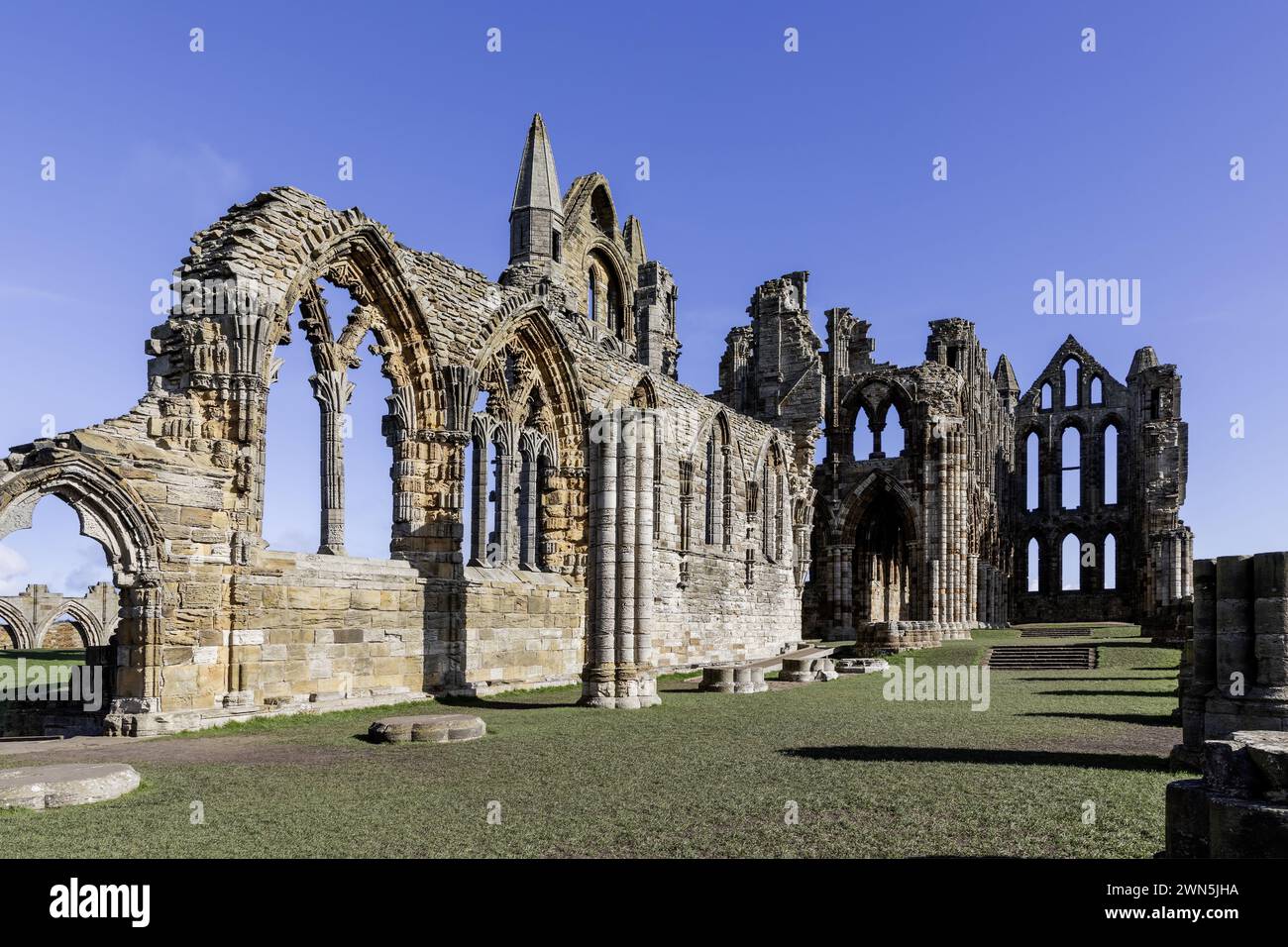 whitby abbazia nel nord dello yorkshire guardando verso est nella rovina della navata dal cielo blu giorno soleggiato sud-ovest Foto Stock