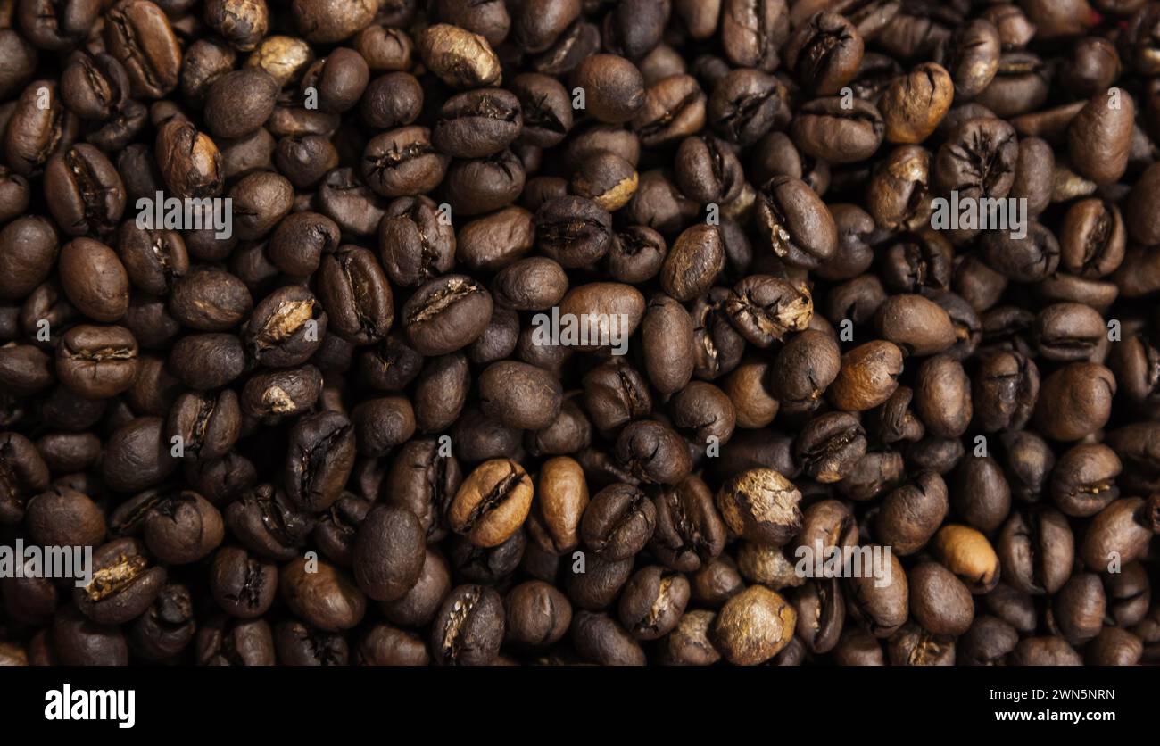 Primi piani in chicchi di caffè arabica selezionati tostati, texture fotografica di sfondo Foto Stock