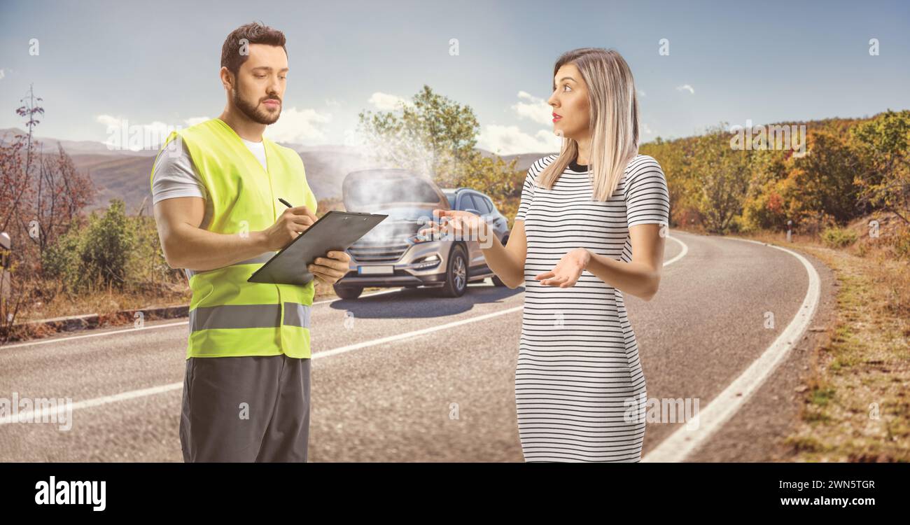 Donna con un'auto rotta sulla strada che parla con un assistente Foto Stock