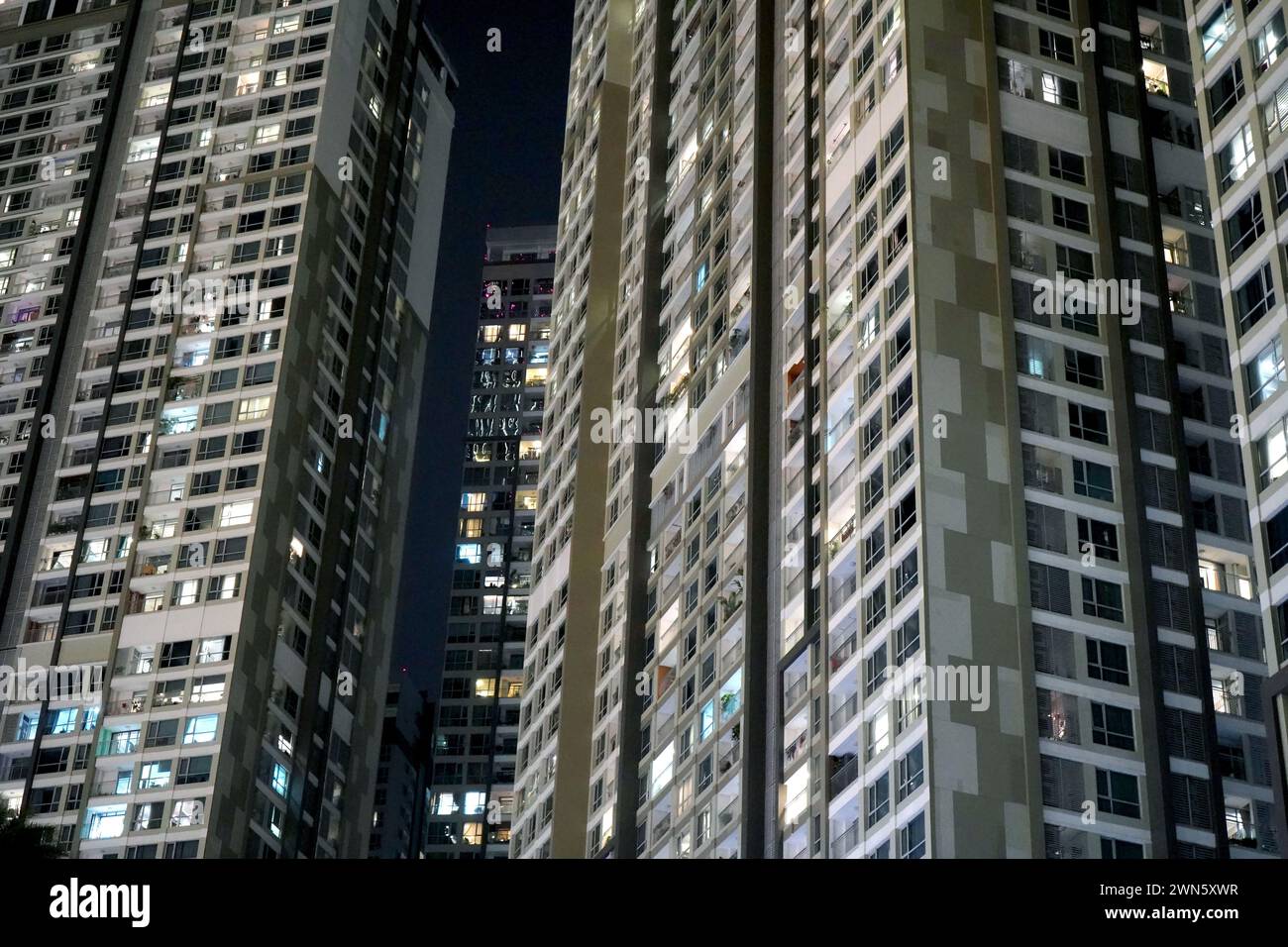 Vista ad angolo basso dei moderni grattacieli di notte, che svettano sopra Foto Stock