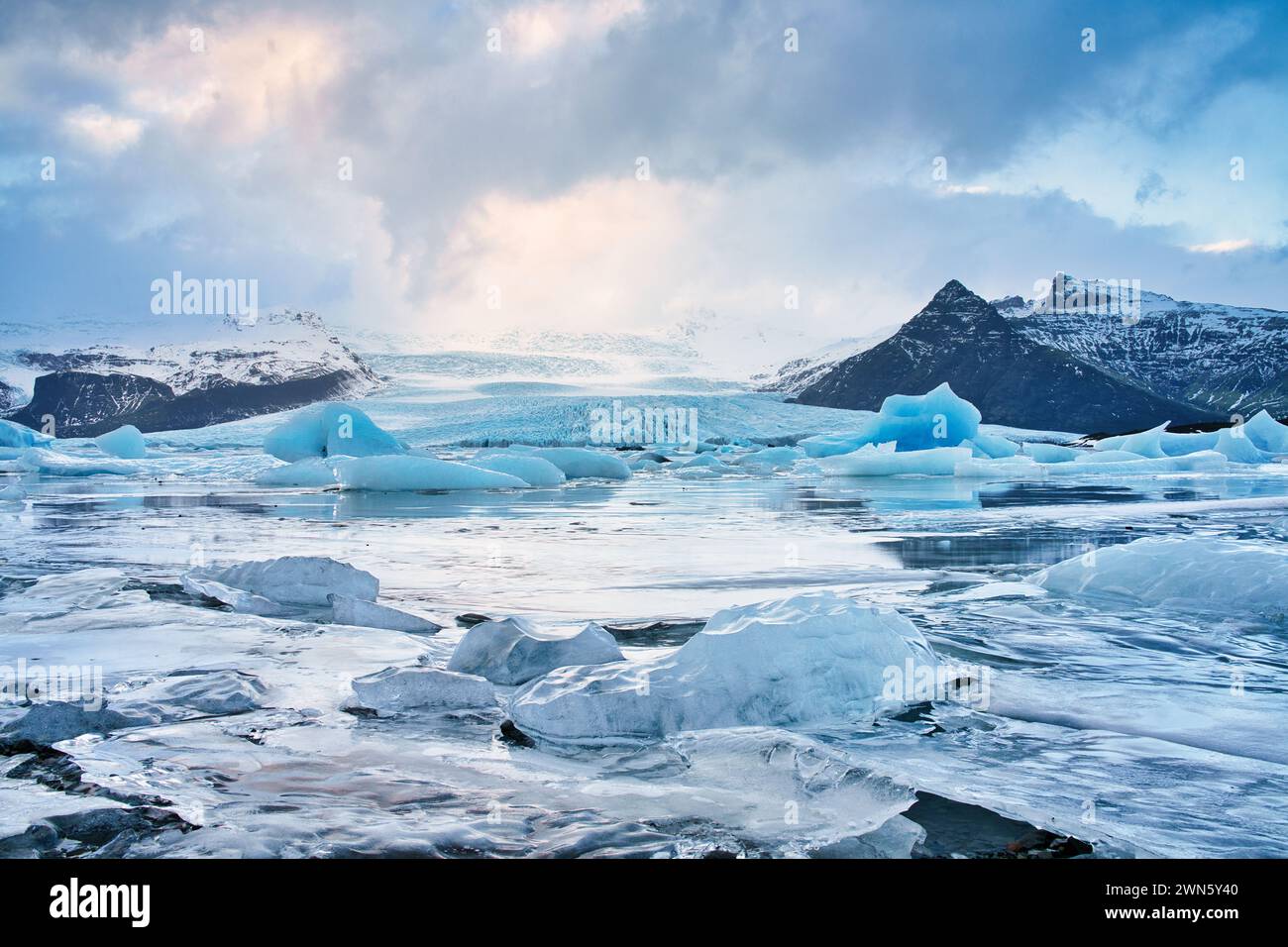 Un lago glaciale islandese con ormeggi di ghiaccio distaccati che galleggiano nelle acque gelide del lago. Foto Stock