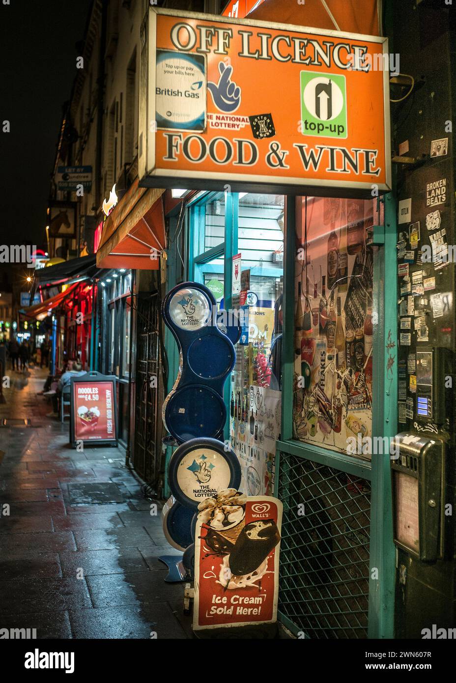 Shopping locale a Londra di notte fuori licenza Foto Stock