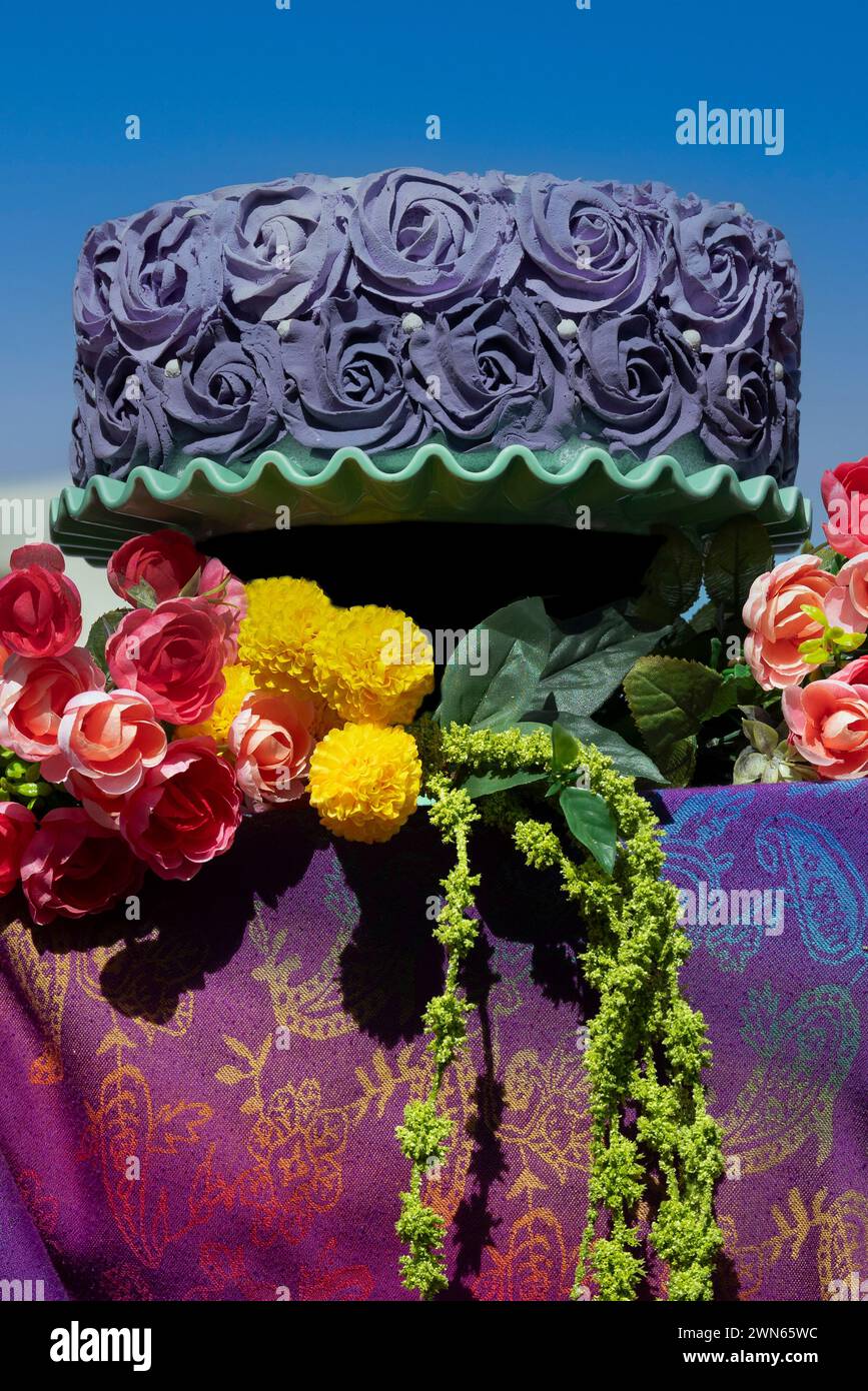 Un'esposizione all'aperto di una glassa viola sbiadita sulla torta con disegni vivaci e colorati per prelibatezze dolciarie presso lo stand della fiera dell'arte Foto Stock