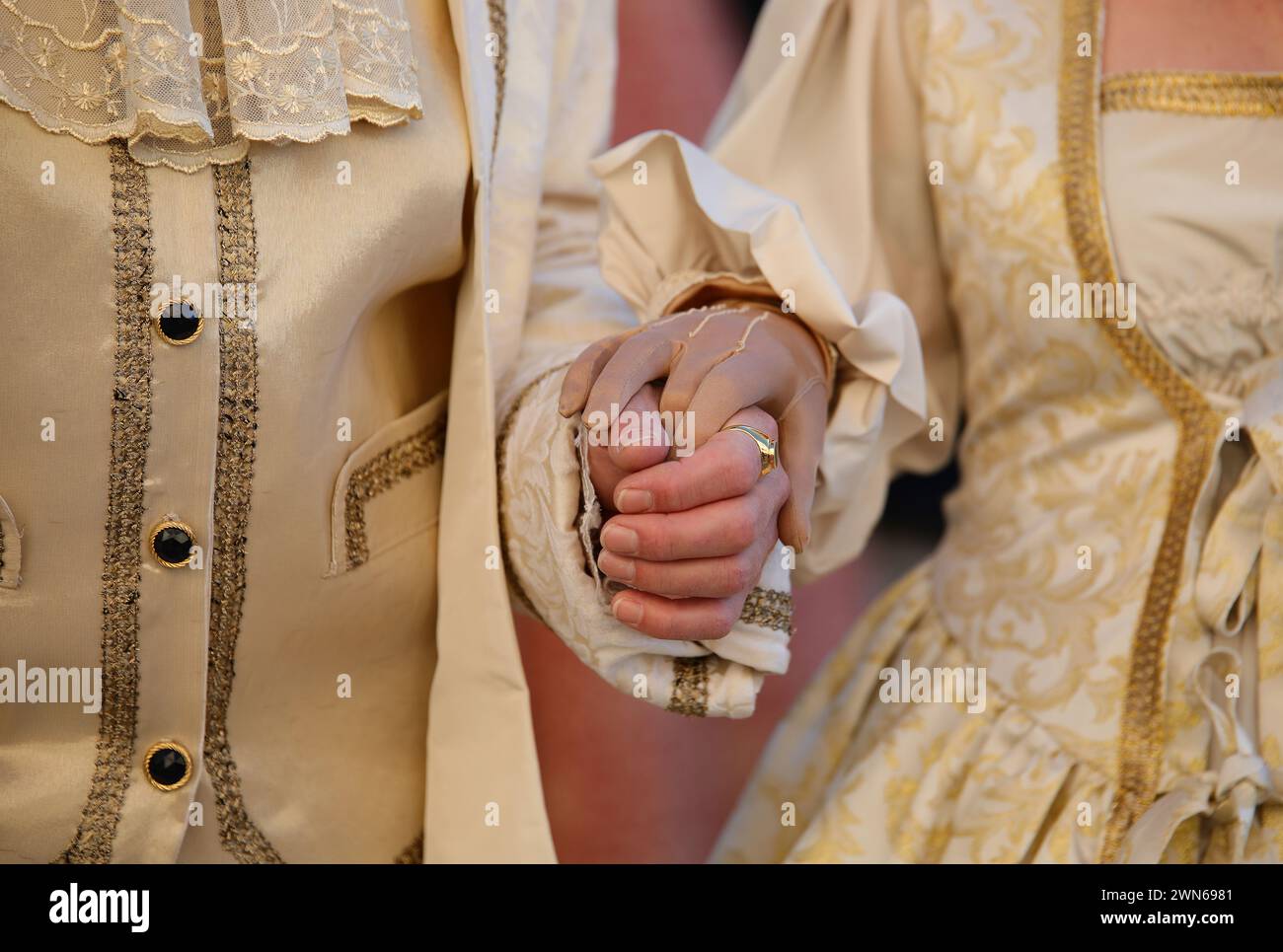 Coppia di nobili amanti che si tengono per mano in abiti antichi e lussuosi aristocratici durante il ballo in maschera Foto Stock