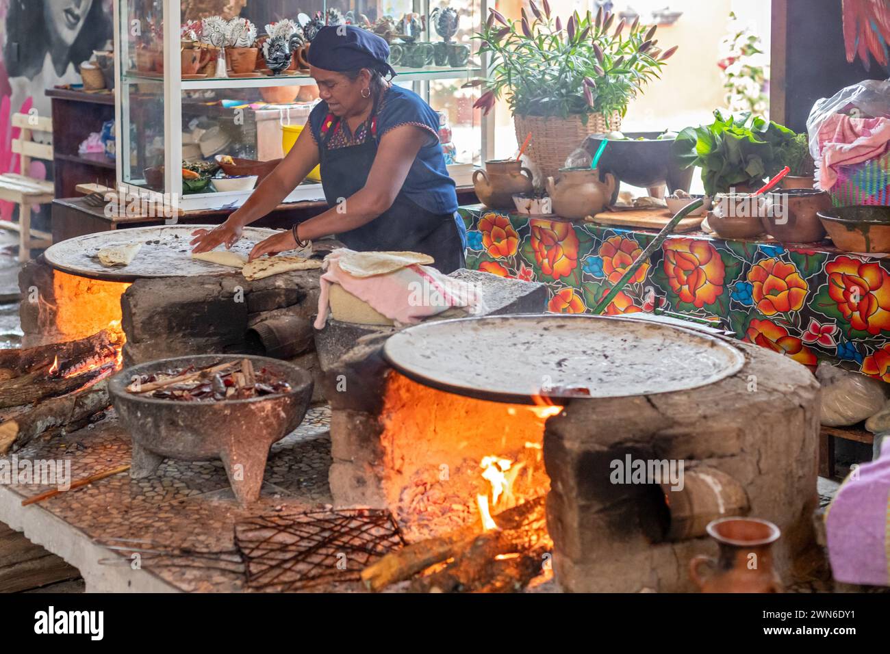 Santa María del Tule, Oaxaca, Messico - Un lavoratore del ristorante Familiar Reynita cucina su una comal sopra di un fuoco a legna. Foto Stock