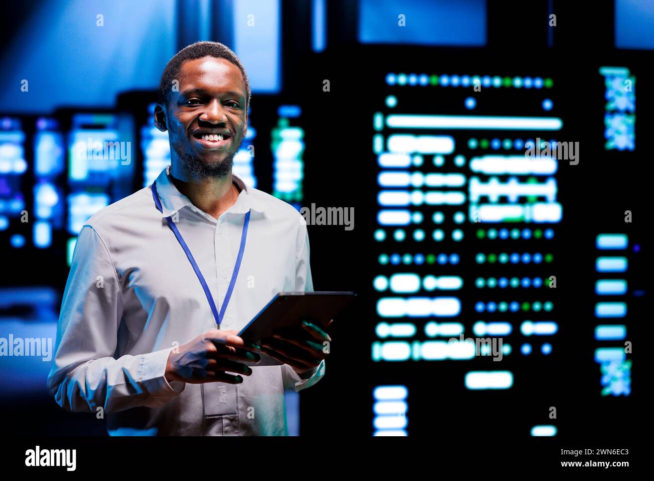 Ritratto di un supervisore sorridente che esegue test diagnostici dei dispositivi del data center per determinare ed eseguire il debug dei problemi software. Un addetto all'assistenza che utilizza un tablet per analizzare i sistemi critici, verificando la presenza di arresti anomali Foto Stock