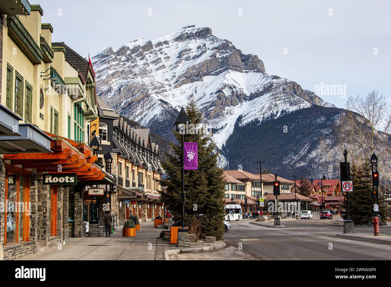 BANFF, CANADA - 22 FEBBRAIO 2024: Banff Avenue nel Banff National Park con Cascade Mountain sullo sfondo. Il sito della città è una delle maggiori t. Canadesi Foto Stock