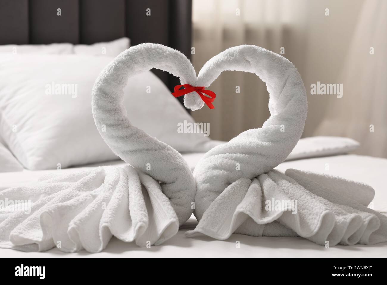 Luna di miele. Cigni fatti di asciugamani sul letto in camera Foto Stock