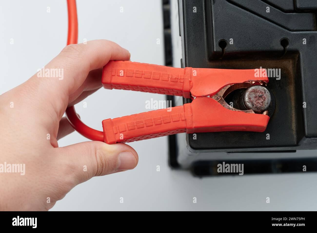 Servizio di batteria per auto. Collegare il filo all'accumulatore di piombo acido Foto Stock