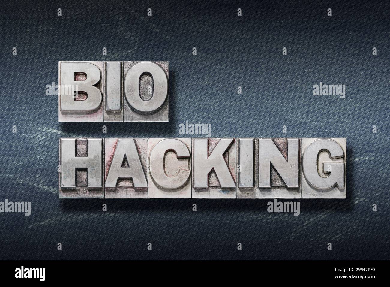 frase di hacking bio realizzata con letterpress metallizzato su sfondo jeans scuro Foto Stock