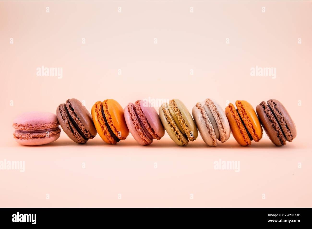 Macaron francesi multicolore su sfondo color pastello Foto Stock