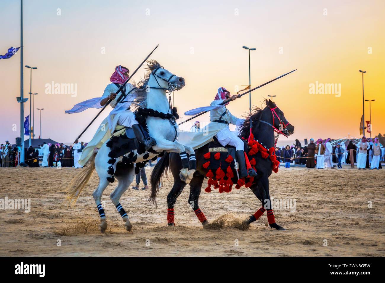 Due giovani cavalieri sauditi in azione. Arabia Saudita. Foto Stock