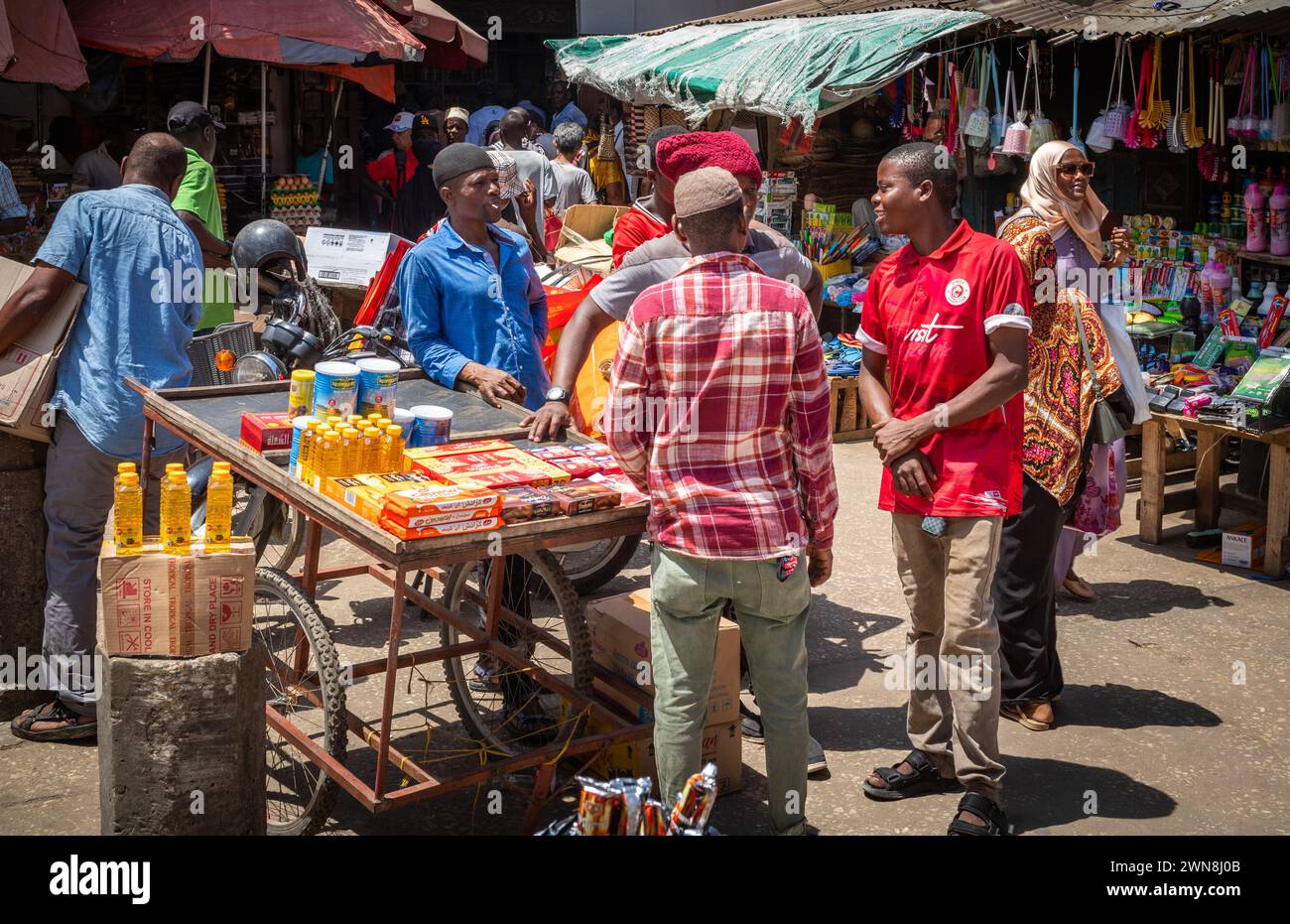 Gli uomini si alzano e chiacchierano al mercato di Stone Town a Zanzibar, Tanzania Foto Stock
