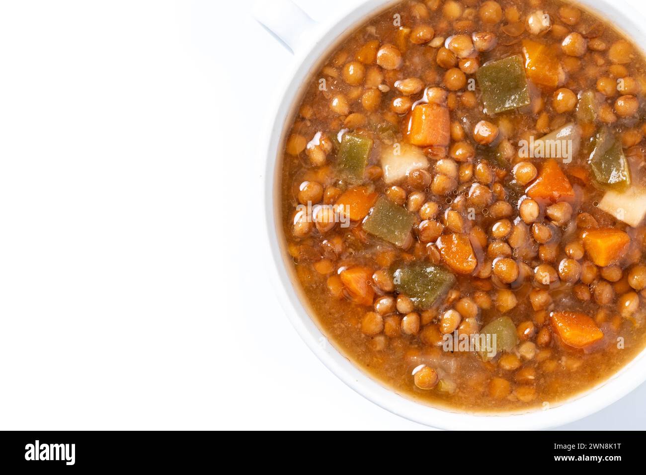 Zuppa di lenticchie con verdure in un recipiente isolato su sfondo bianco Foto Stock