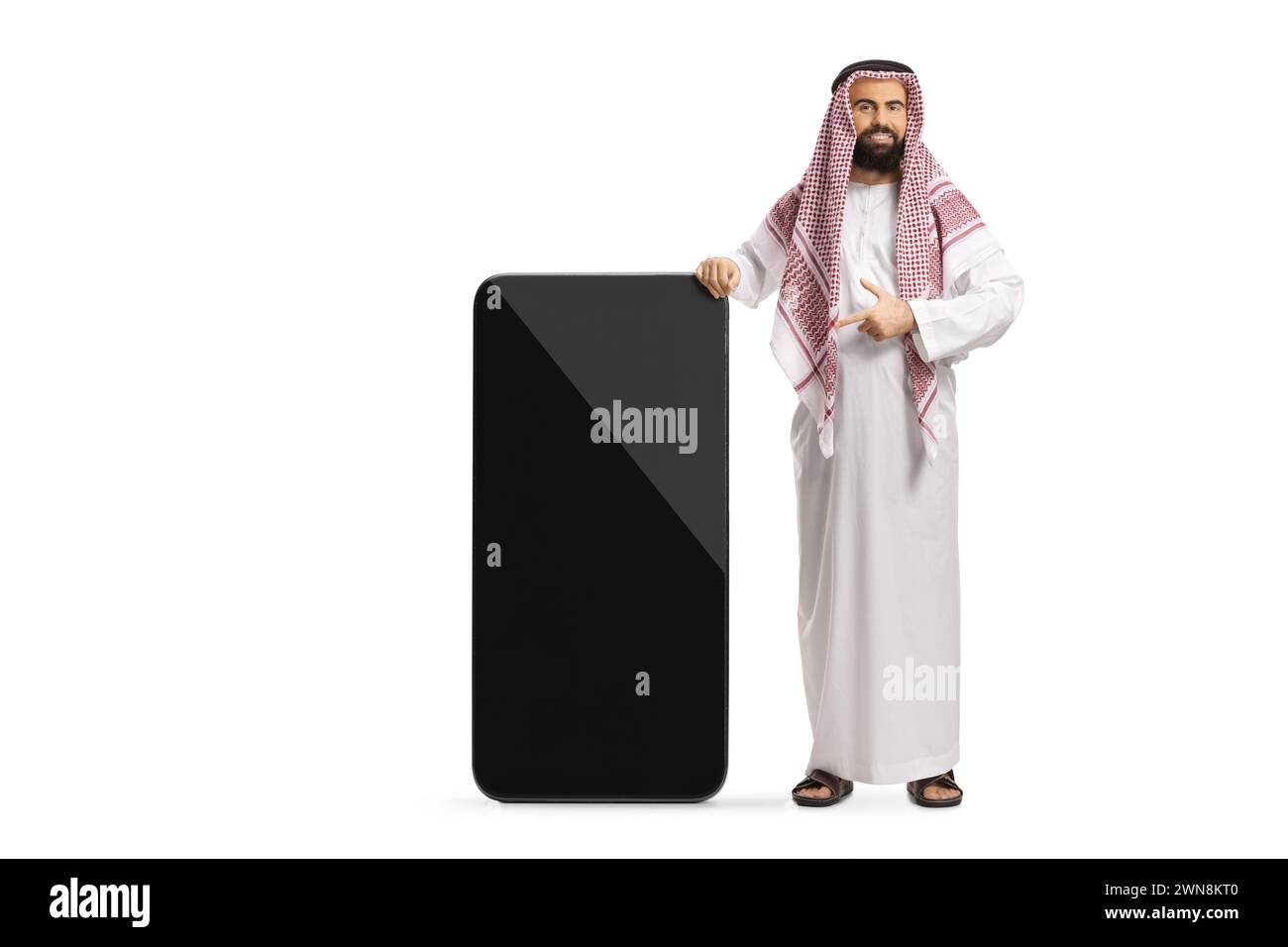 arabo saudita in abiti etnici che puntano a un grande telefono cellulare con schermo vuoto isolato su sfondo bianco Foto Stock
