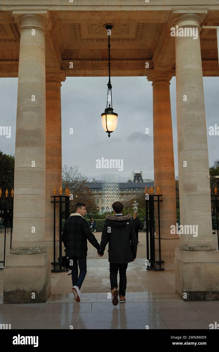 I due giovani che camminano mano nella mano sotto un lampione a Parigi Foto Stock I due giovani che camminano mano nella mano sotto un lampione a Parigi Foto Stock