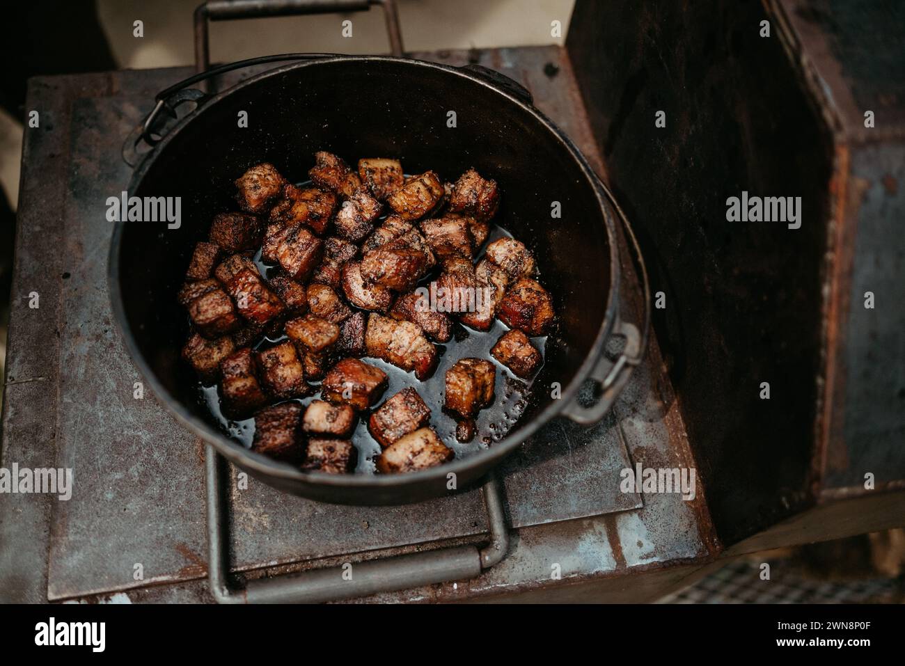 Pancetta di maiale in padella di ghisa su fumatori Foto Stock