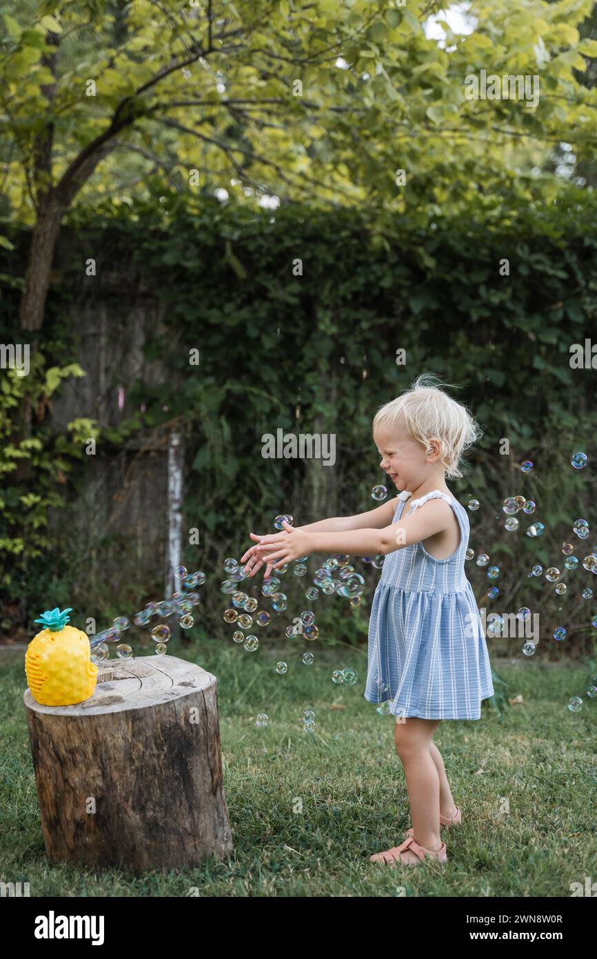 Piccola ragazza che gioca a bolle nel cortile di Tulsa OK Foto Stock