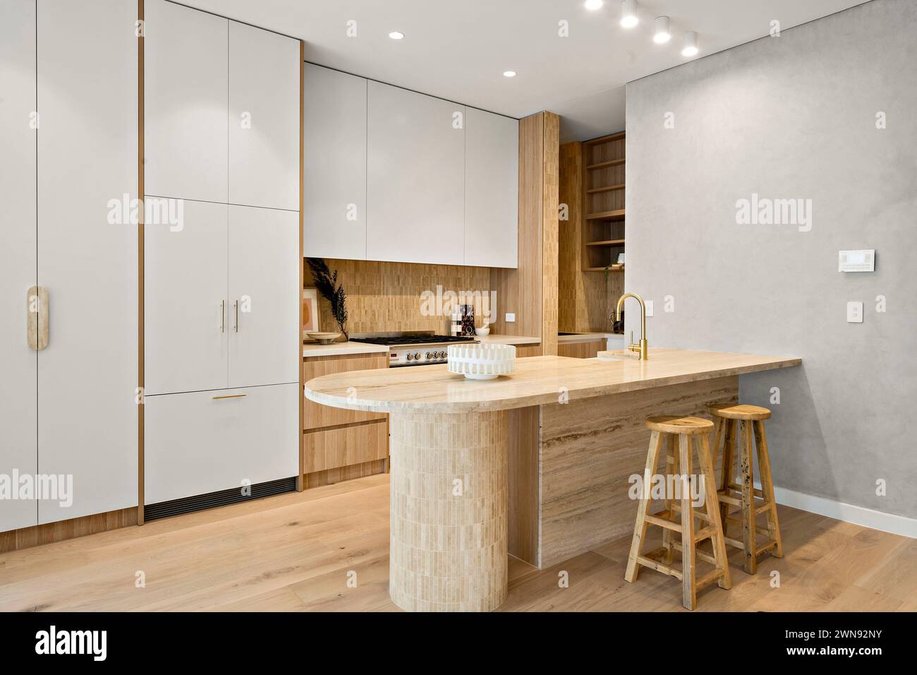 Una cucina con pavimenti in legno duro e l'isola centrale Foto Stock