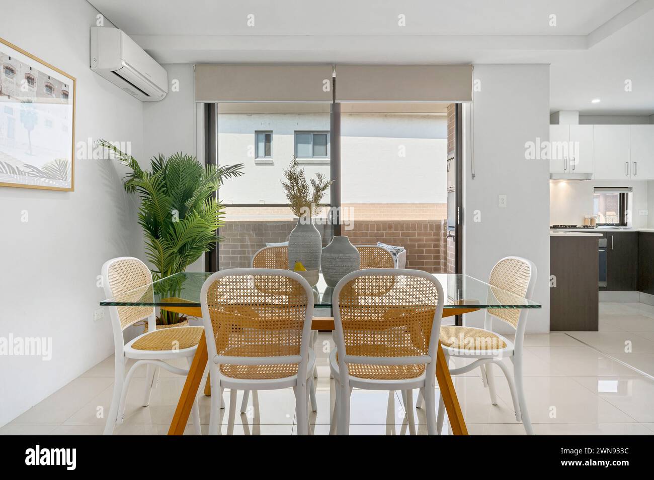 Un tavolo da pranzo contemporaneo con piano in vetro e sedie in un ambiente moderno Foto Stock