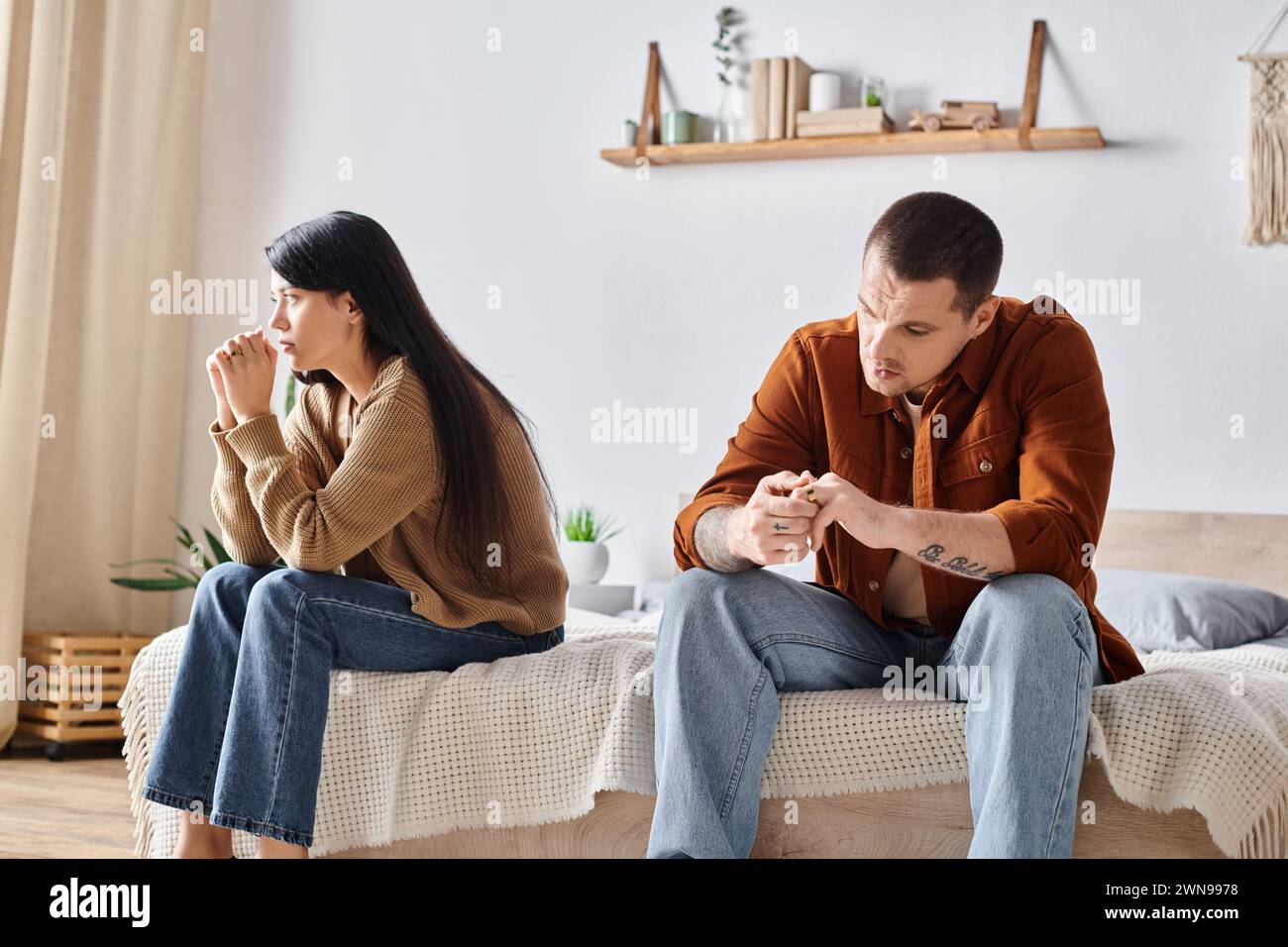 coppia multietnica depressa seduta in camera da letto a casa, concetto di difficoltà di relazione Foto Stock