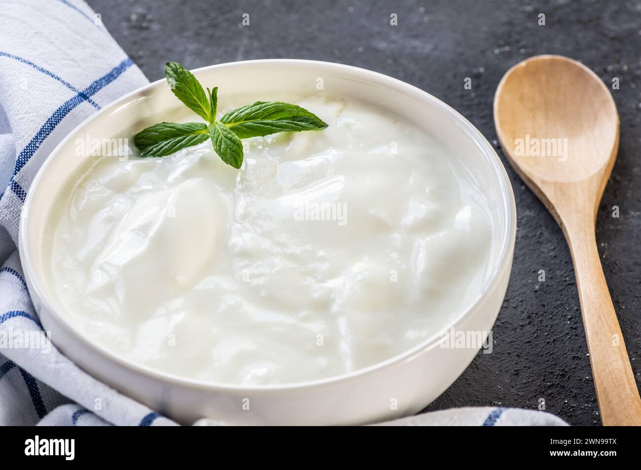Yogurt fatto in casa con panna in ciotola su tavola rustica, cibo sano Foto Stock