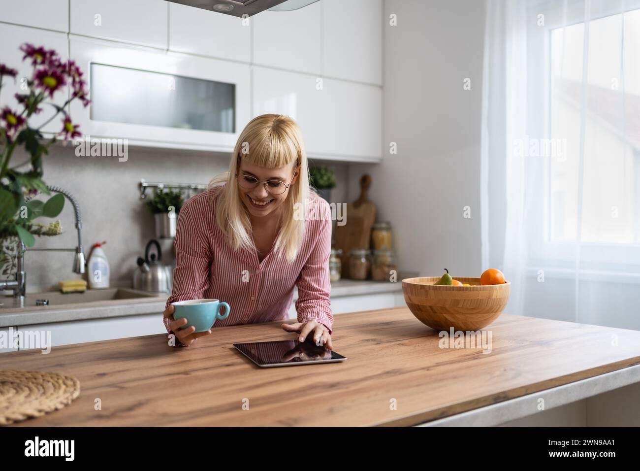 Giovane donna d'affari, titolare di una piccola azienda, imprenditore esperto di startup, sviluppatore di marketing e strategia di prodotto, bevendo il primo caffè nel gattino Foto Stock