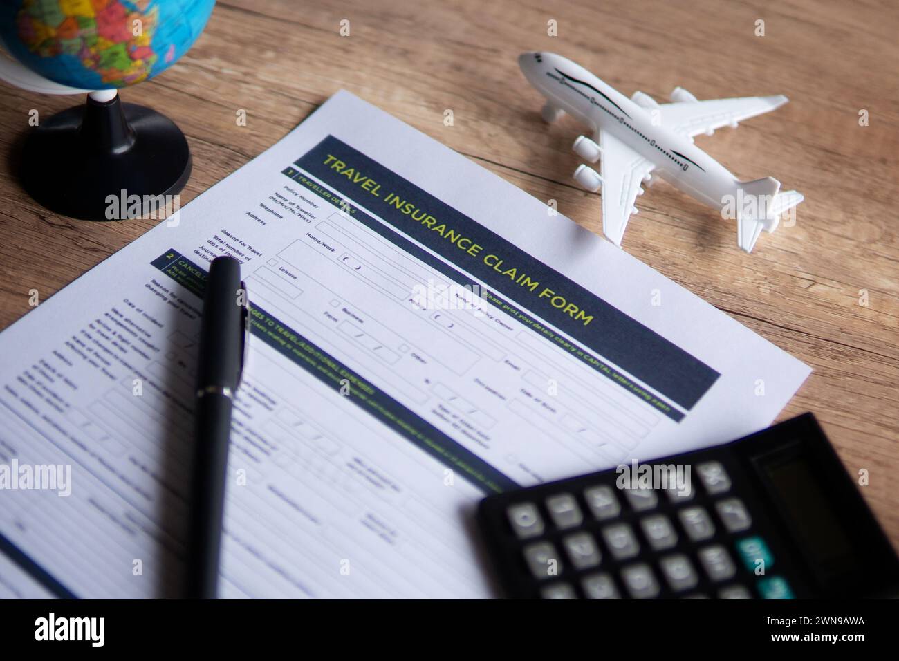 Immagine selettiva del modulo di richiesta dell'assicurazione di viaggio su un tavolo di legno. Concetto di viaggio, protezione e assicurazione. Foto Stock