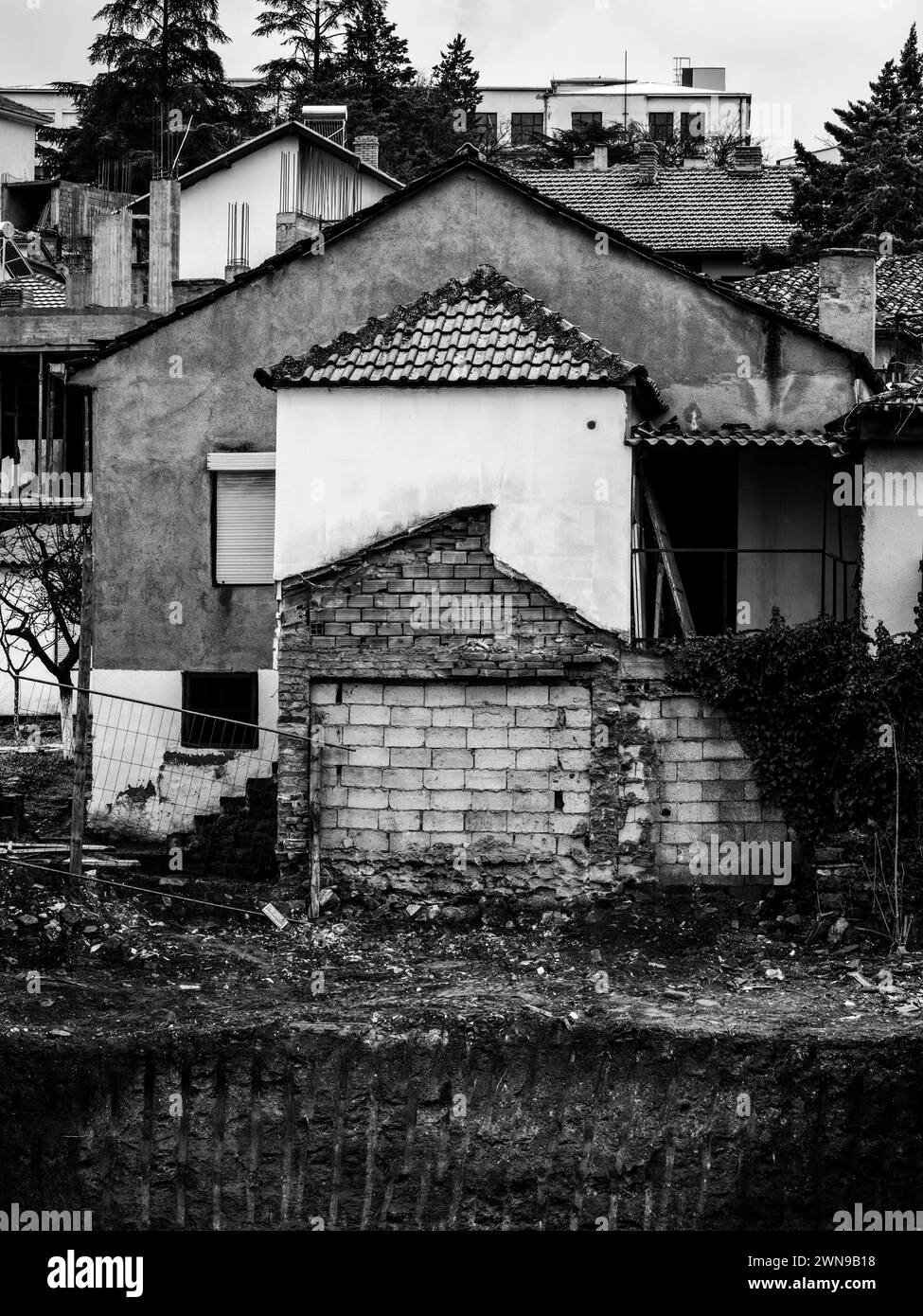 Decadimento superiore a. Strati di distruzione sui tetti delle vecchie case. Bianco e nero. Monocromatico. Foto Stock