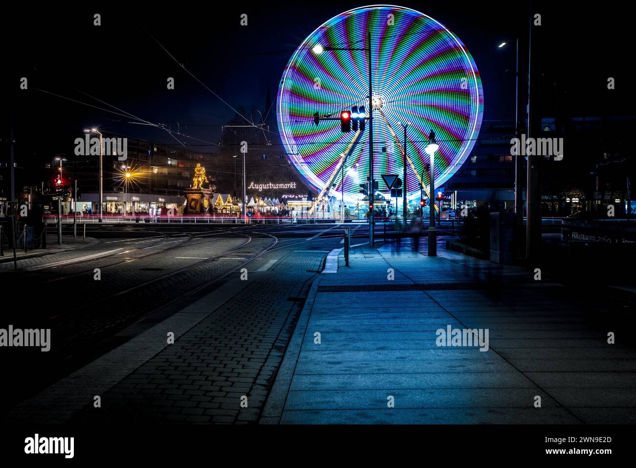 Ruota panoramica illuminata di notte con schemi di luce dinamici in un ambiente urbano, Augustusmarkt Augustusbruecke Dresden Foto Stock