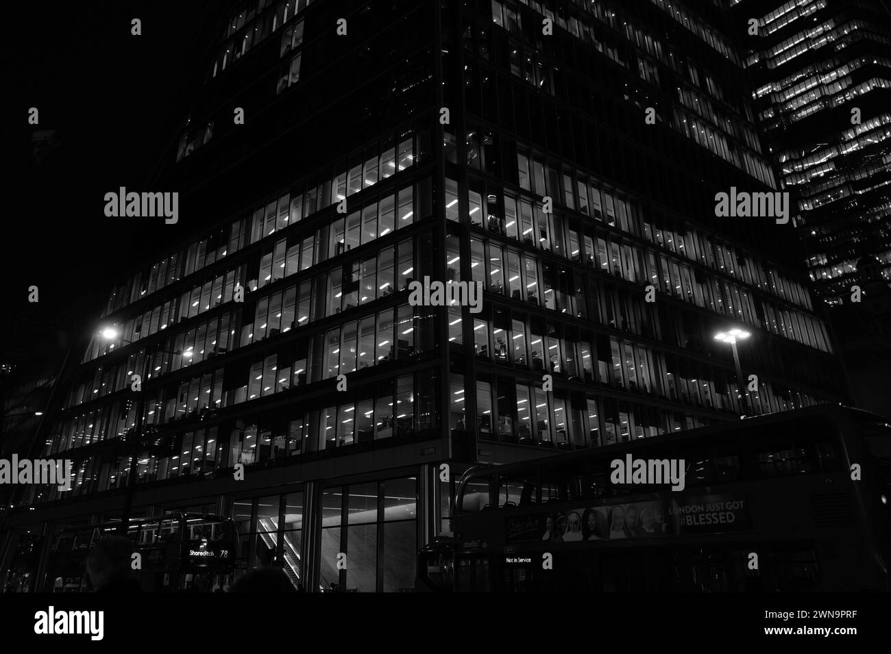 Potente paesaggio architettonico monocromatico astratto di uffici con scraper illuminati di notte su Bishopsgate vicino a Liverpool Street nella City di Londra. Foto Stock