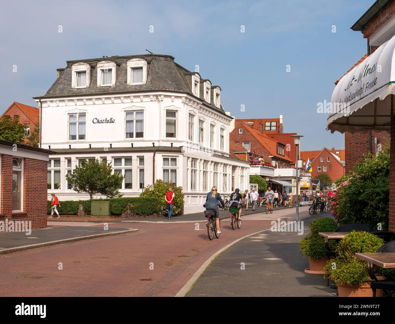 Scena di strada con ciclisti nella città della Frisia orientale dell'isola Juist, bassa Sassonia, Germania Foto Stock