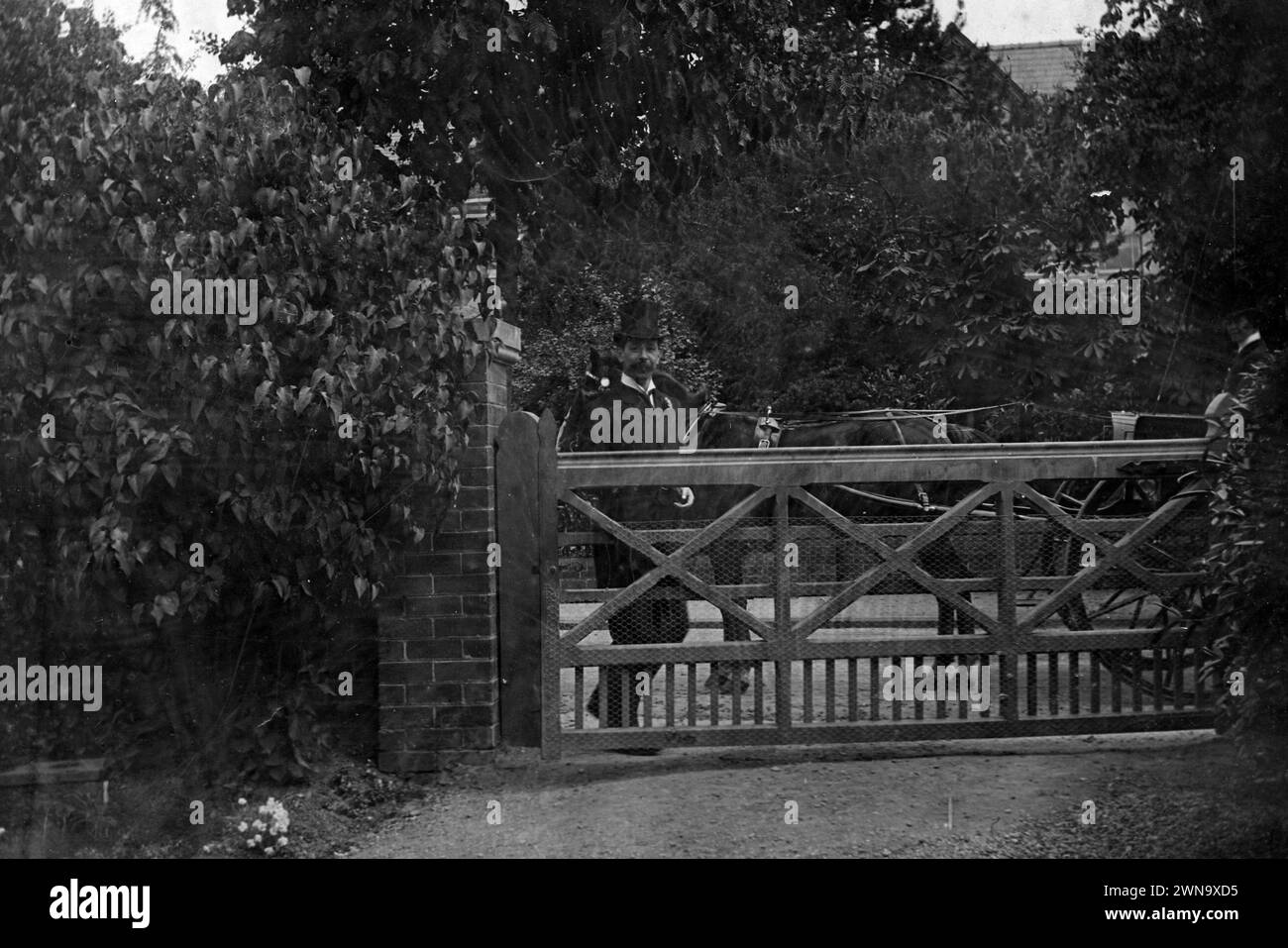 1897 storica fotografia in bianco e nero del Dottor Lane in Top Hat a Wooden Gate with Horse and Cart Visiting Patient, Hereford, Herefordshire, Inghilterra, Regno Unito Foto Stock