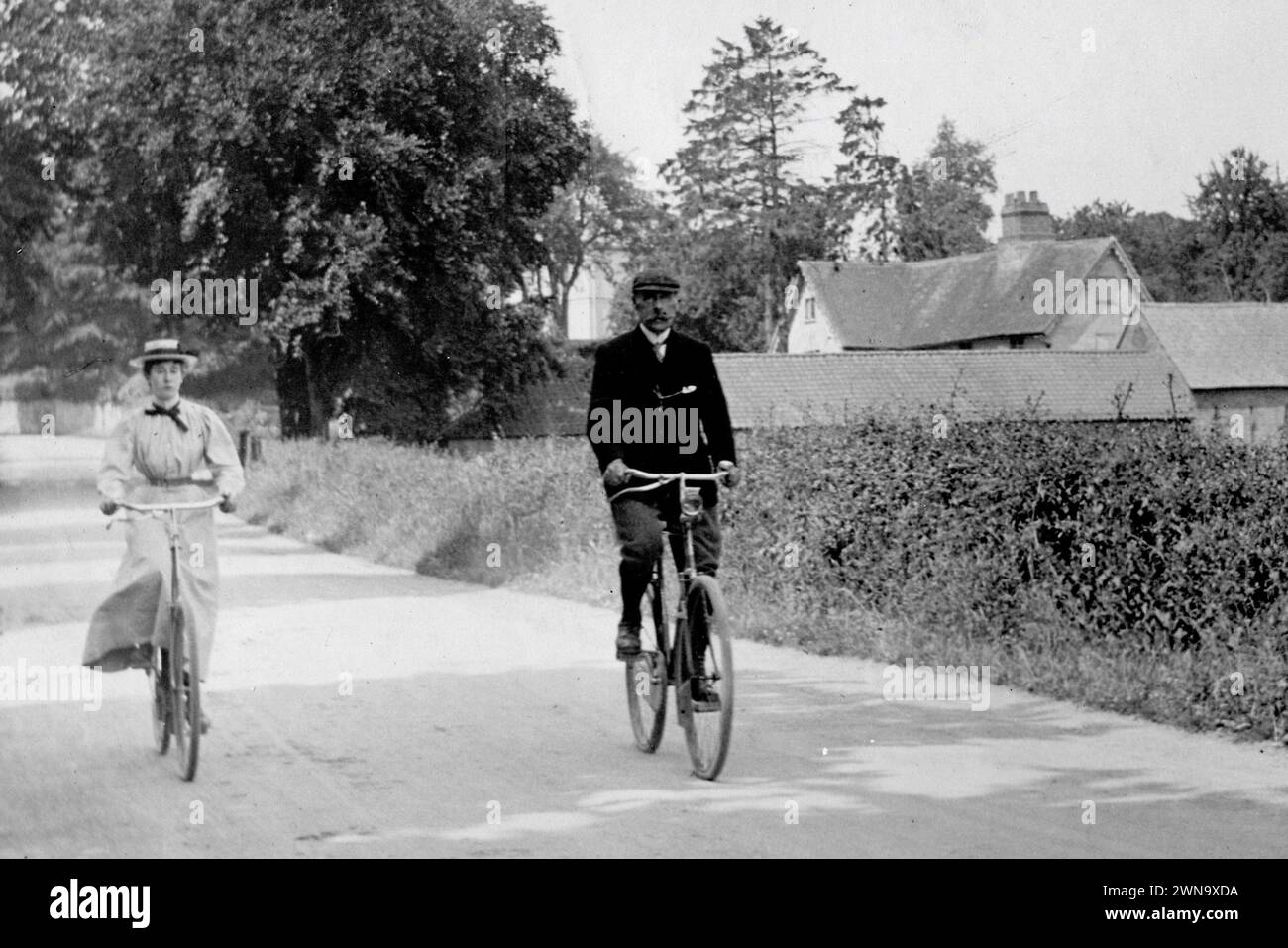 1897 Fotografia storica in bianco e nero di Mr e Miss Richards in bicicletta su una Country Lane vicino a Hereford, Herefordshire, Inghilterra, Regno Unito Foto Stock
