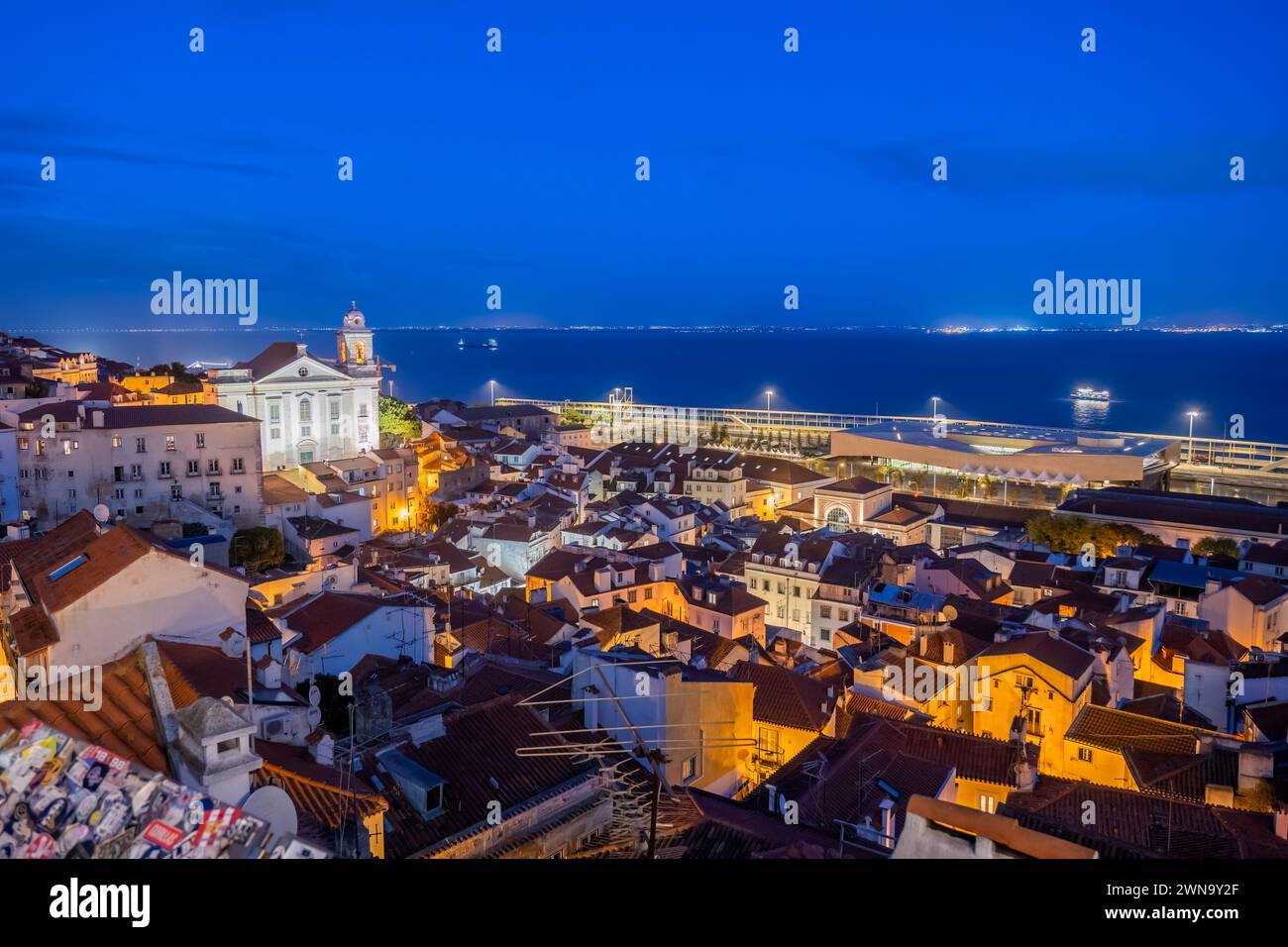 Città di Lisbona di notte in Portogallo. Vista sul quartiere di Alfama sul fiume Tago. Foto Stock
