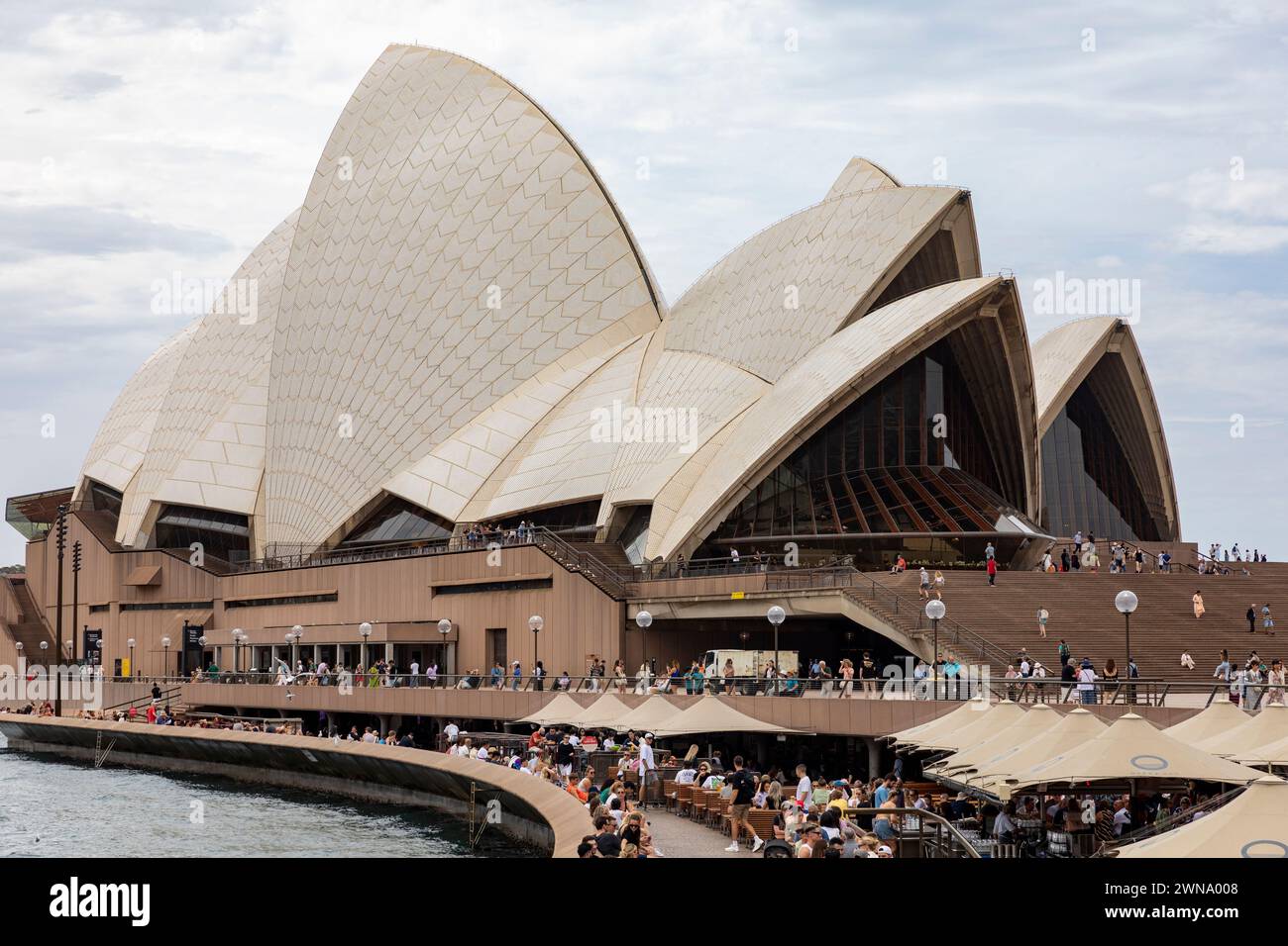 Edificio dell'Opera House di Sydney, 2024, a bennelong Point a Sydney, con persone che gusteranno il pranzo al bar e ristorante dell'opera di Sydney, iconico Foto Stock