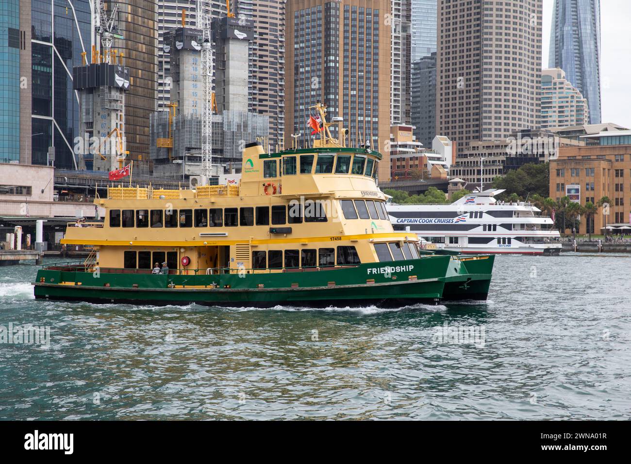 Sydney Cove Australia, Sydney Ferry MV Friendship parte dal terminal dei traghetti di Circular Quay, dagli edifici degli uffici di Sydney e dagli hotel alle spalle, New South Wales, Australia, 2024 Foto Stock