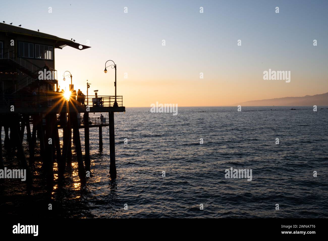 SANTA MONICA, CALIFORNIA, Stati Uniti: Il sole tramonta sull'Oceano Pacifico presso il famoso molo di Santa Monica a Santa Monica, California. Foto Stock