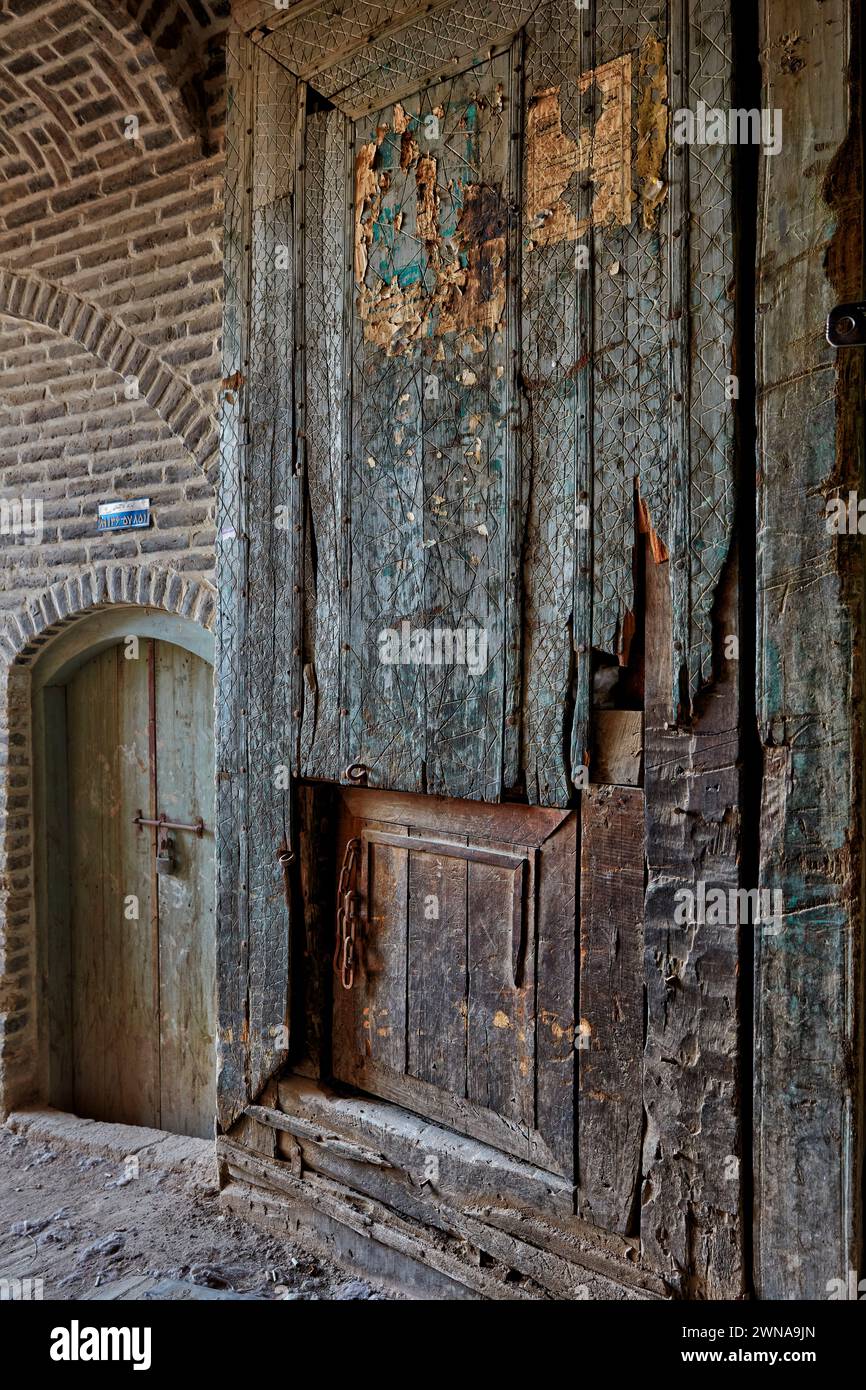 Vista ravvicinata di un'enorme porta di legno nella città vecchia di Yazd, Iran. Foto Stock