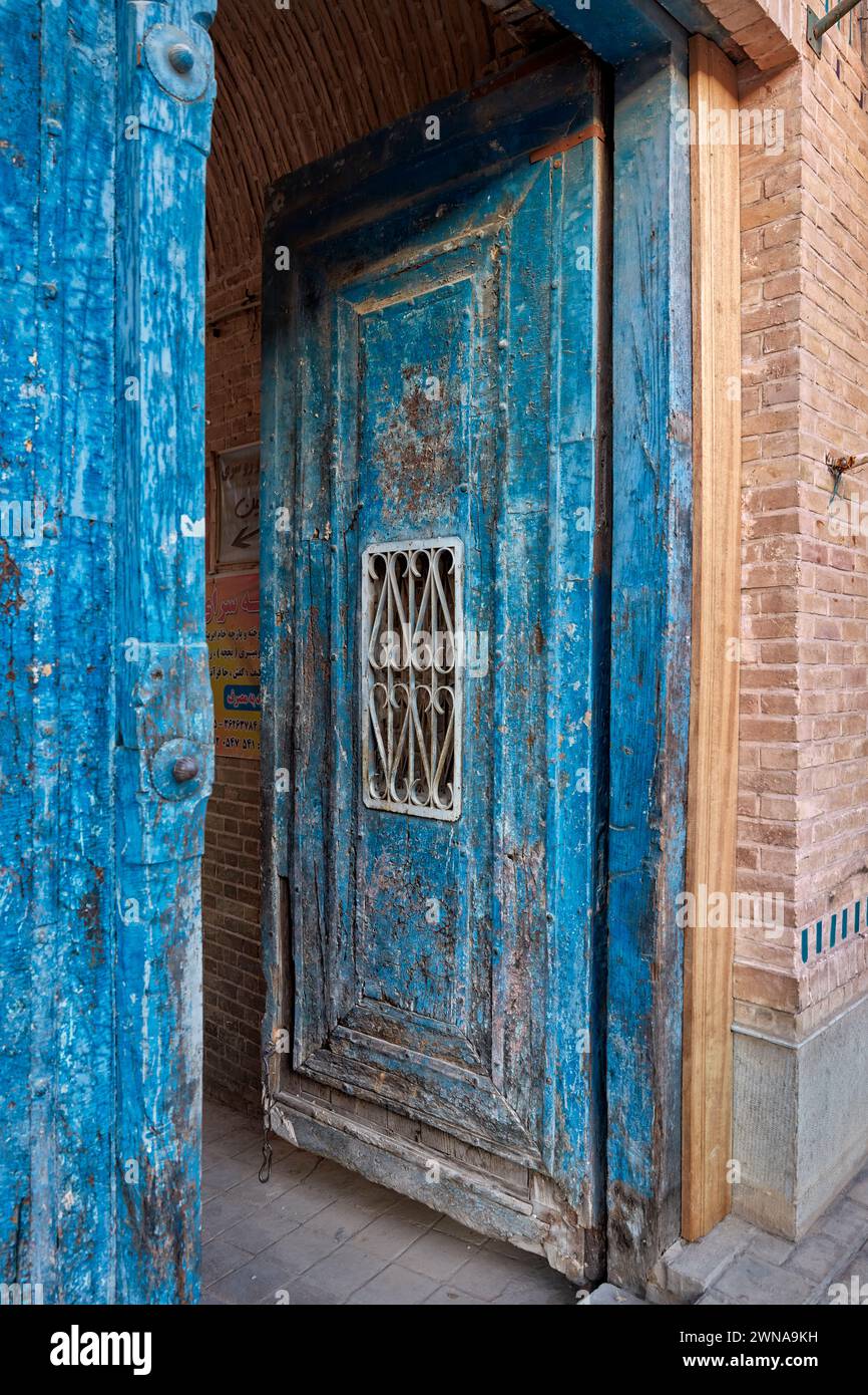 Vista ravvicinata di una vecchia porta blu in legno nel centro storico di Yazd, Iran. Foto Stock