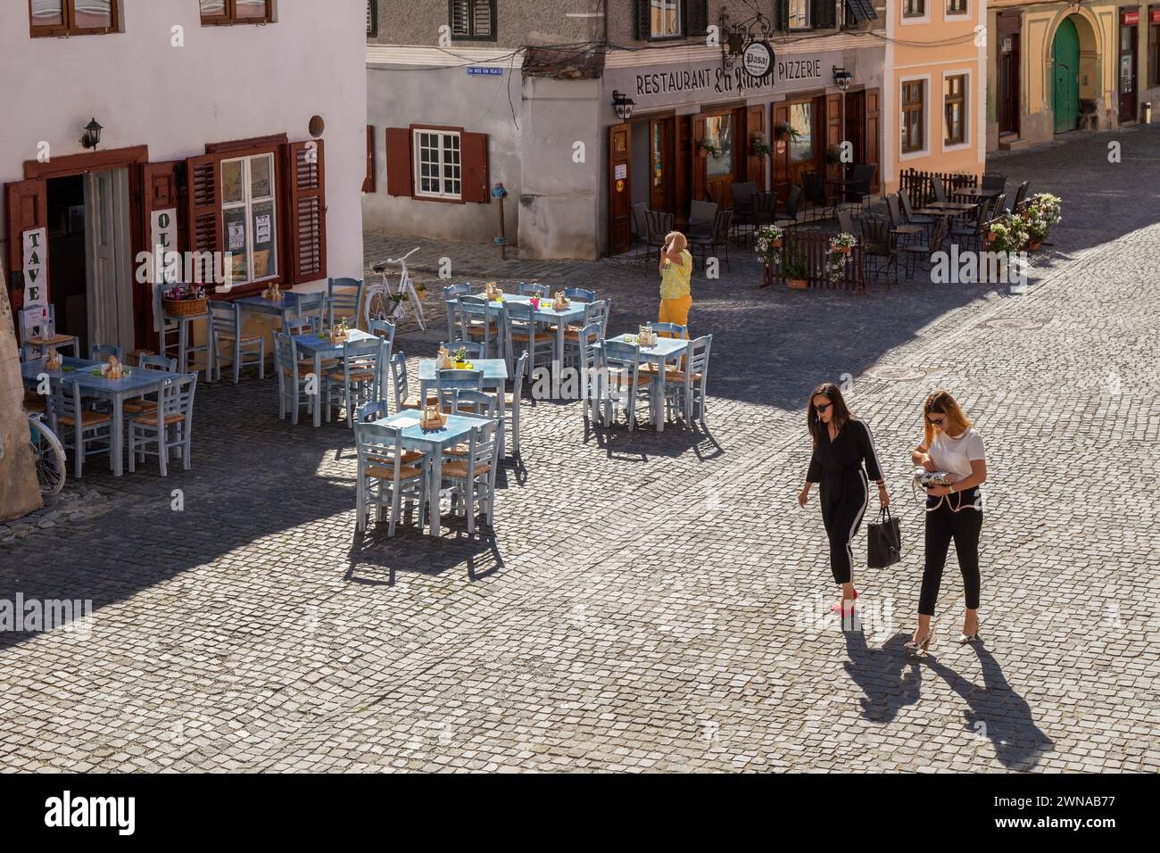SIBIU, TRANSILVANIA, ROMANIA - 8 LUGLIO 2020: Piccole terrazze e belle ragazze nel centro storico della città, tra Tower Street e passa Foto Stock