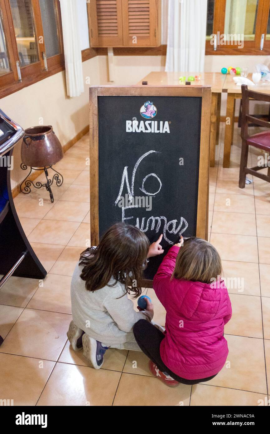 Due bambini si esercitano a scrivere sul cartello "vietato fumare". Foto Stock